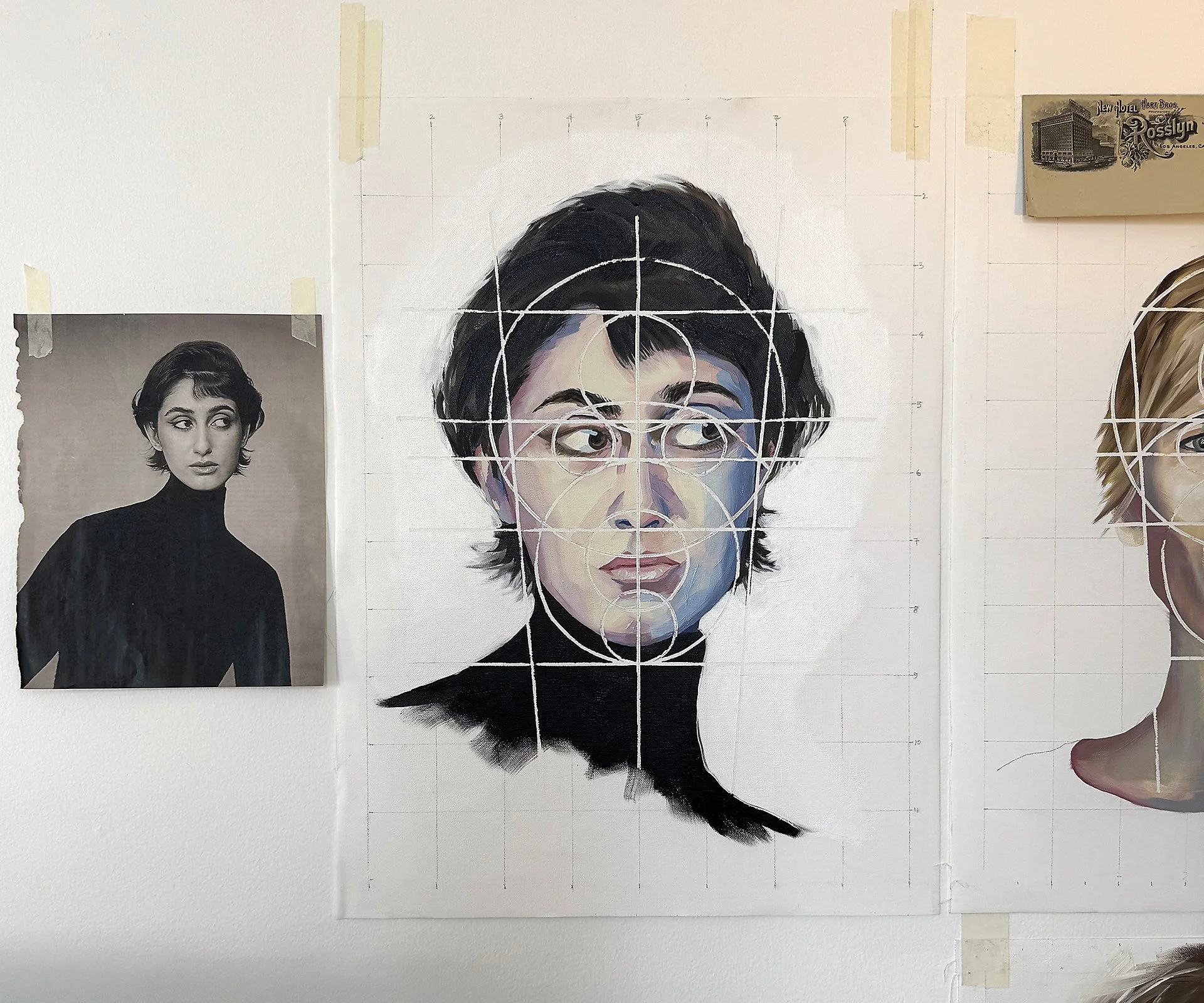 A painted portrait of Rama Duwaji with short, dark hair, wearing a black turtleneck, with geometric circles and grid lines overlaid on the face, mounted on a wall with an original black and white photo of the same person taped nearby.