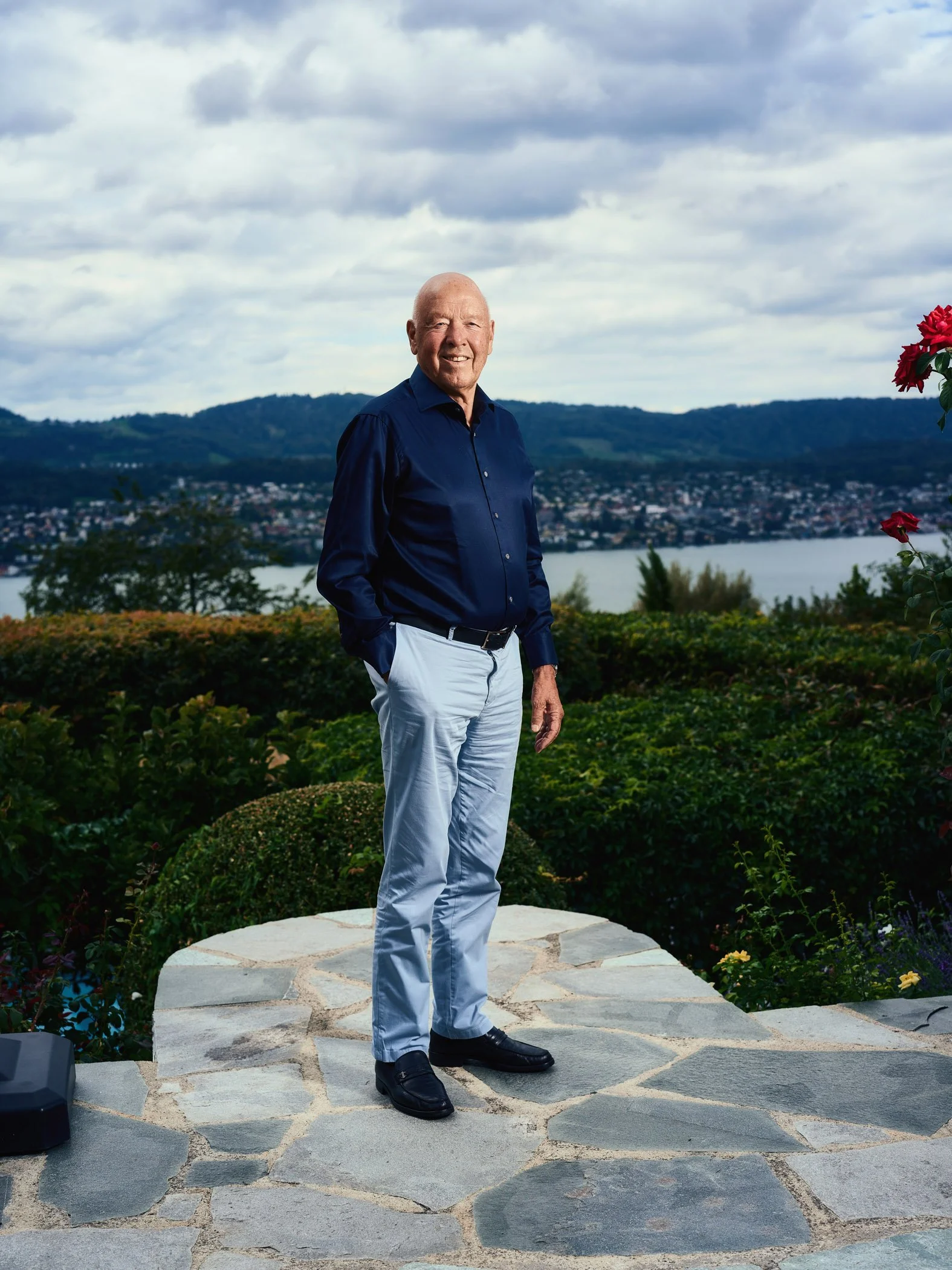 Theo Müller steht im Garten seiner Villa mit Blick auf den Zürichsee.