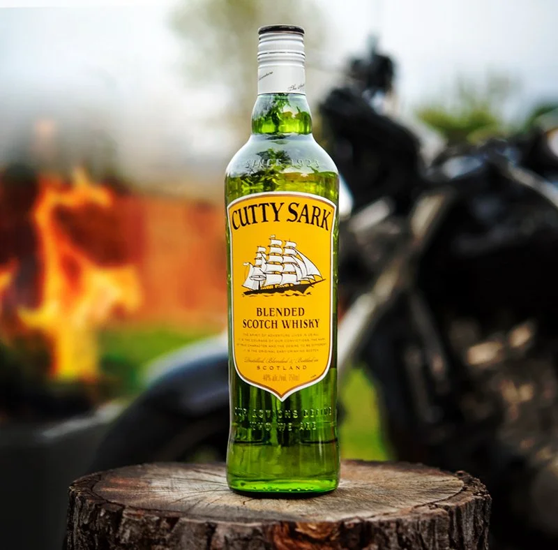 Cutty Sark whiskey bottle photographed in an outdoor lifestyle setting