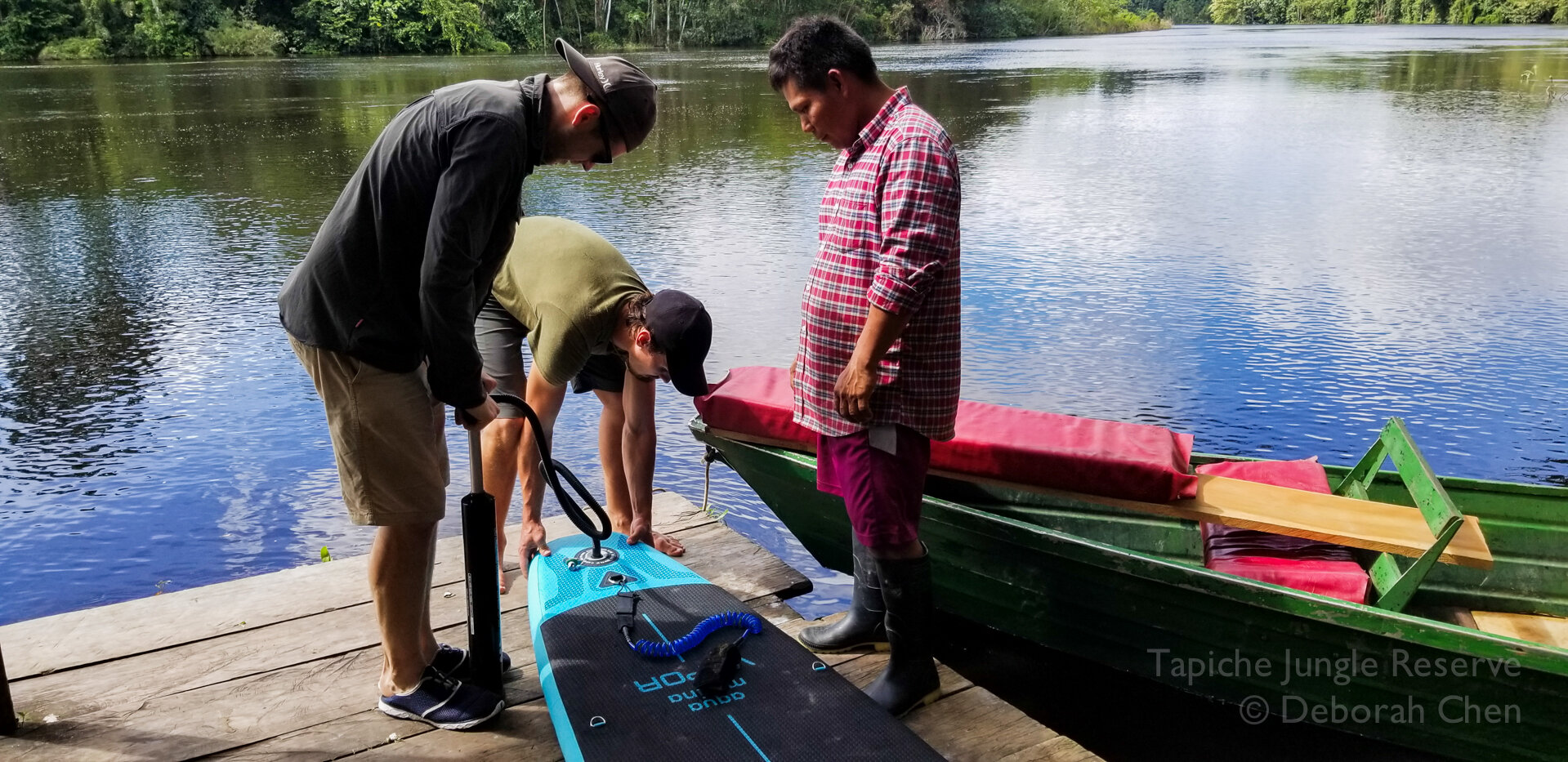  Alex Vail, Toby Nowlan and Tapiche guide Jose Murayari set up an inflatable stand-up paddleboard to navigate tight turns in the flooded forest 