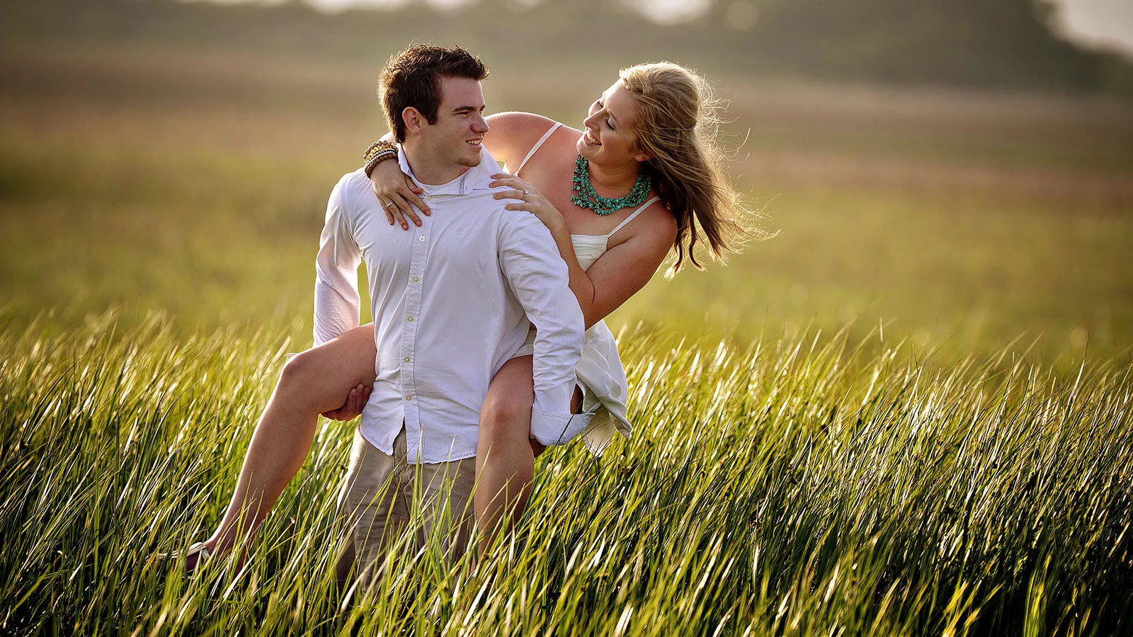 Fun Engagement - Tall grass and sea in the background.