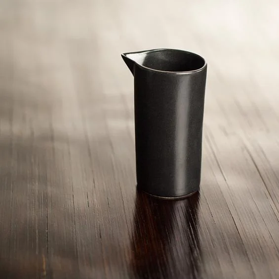 Small ceramic Milk Jug in Matt Black. Here, a higher angle brought out the grain in the wooden table.