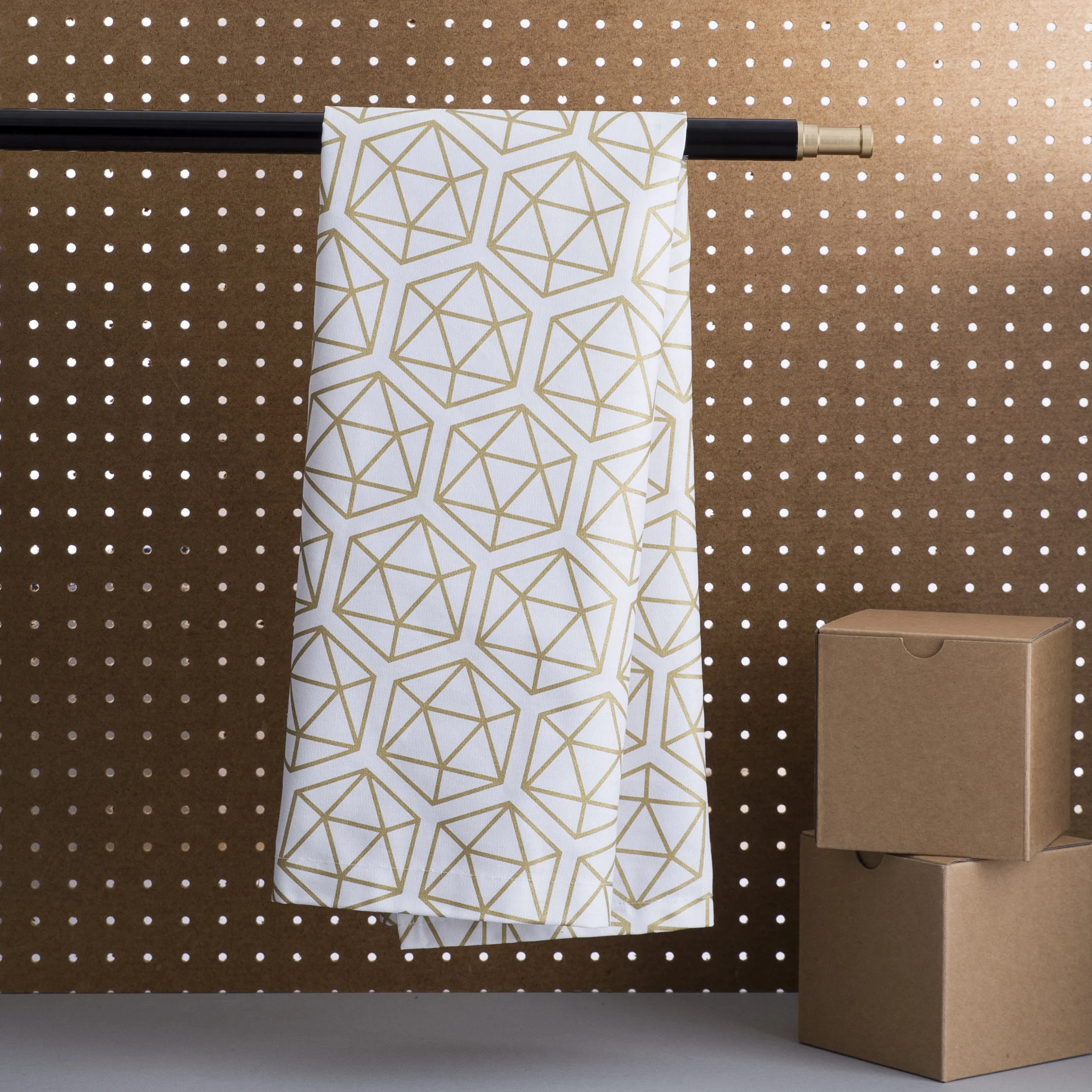 Tea Towel hanging of studio stand with pegboard and light behind