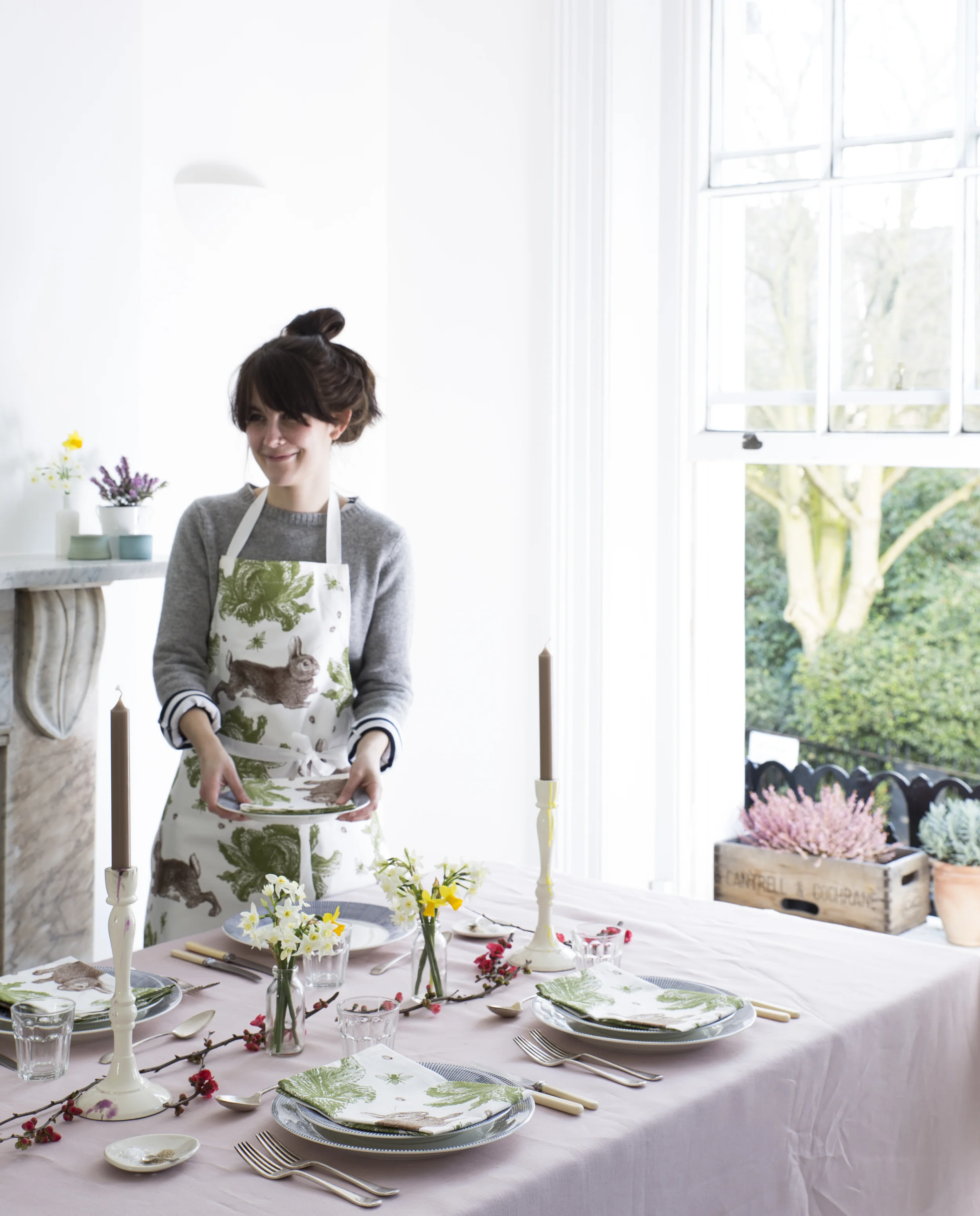 Table setup in front of right window with marble mantelpiece to left