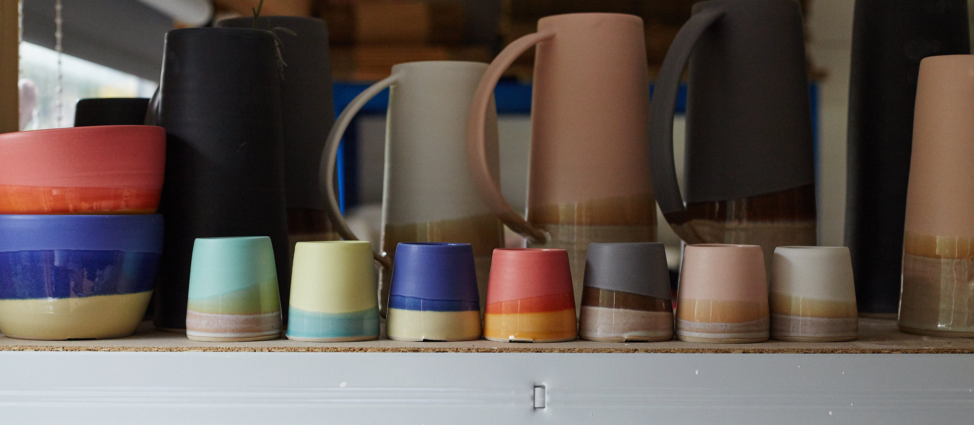 A range of colourful glazes on Emma's cups.