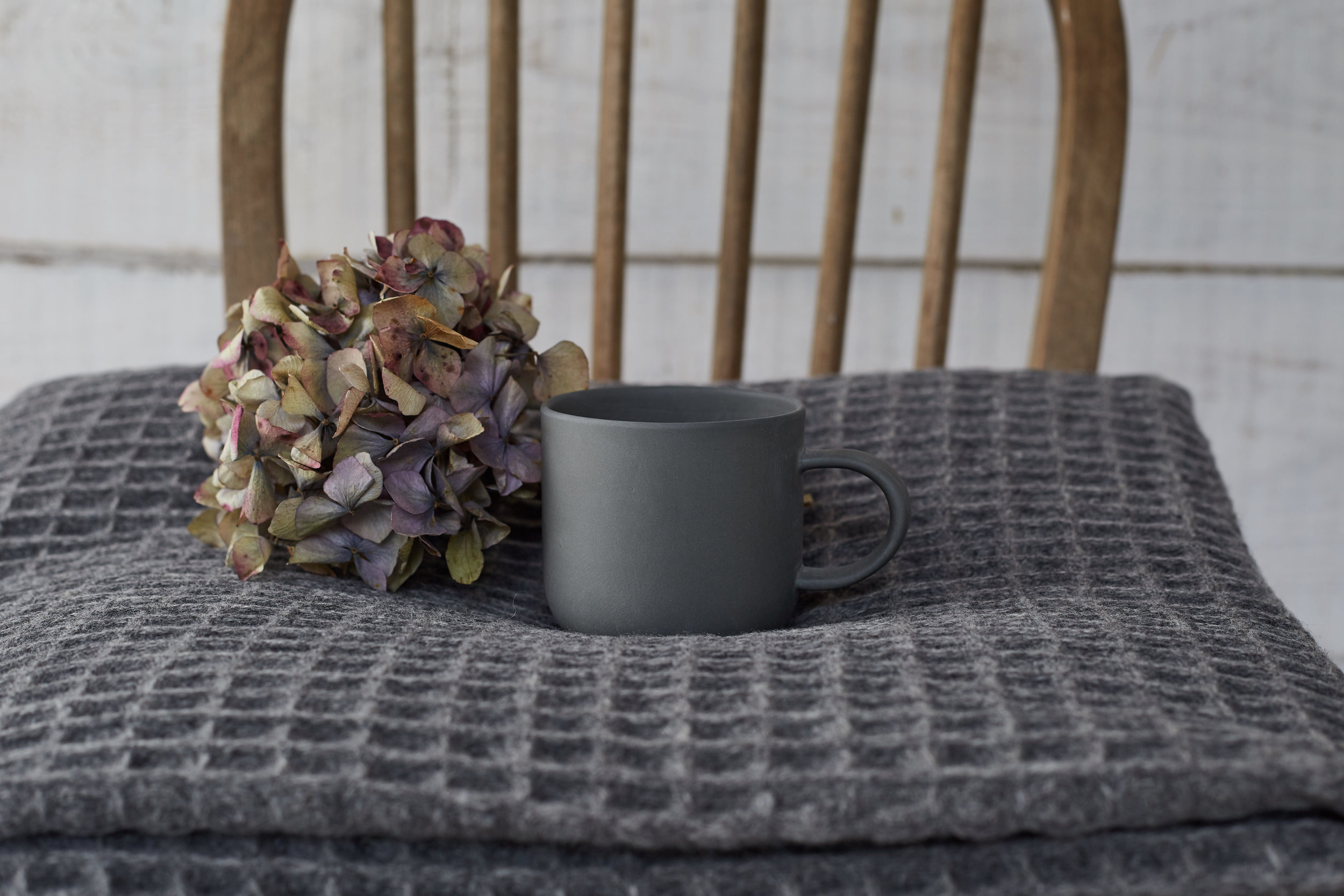 A waffle blanket from Damson&Slate, styled with a dried Hydrangeaand a lovely cup from Sue pryke.