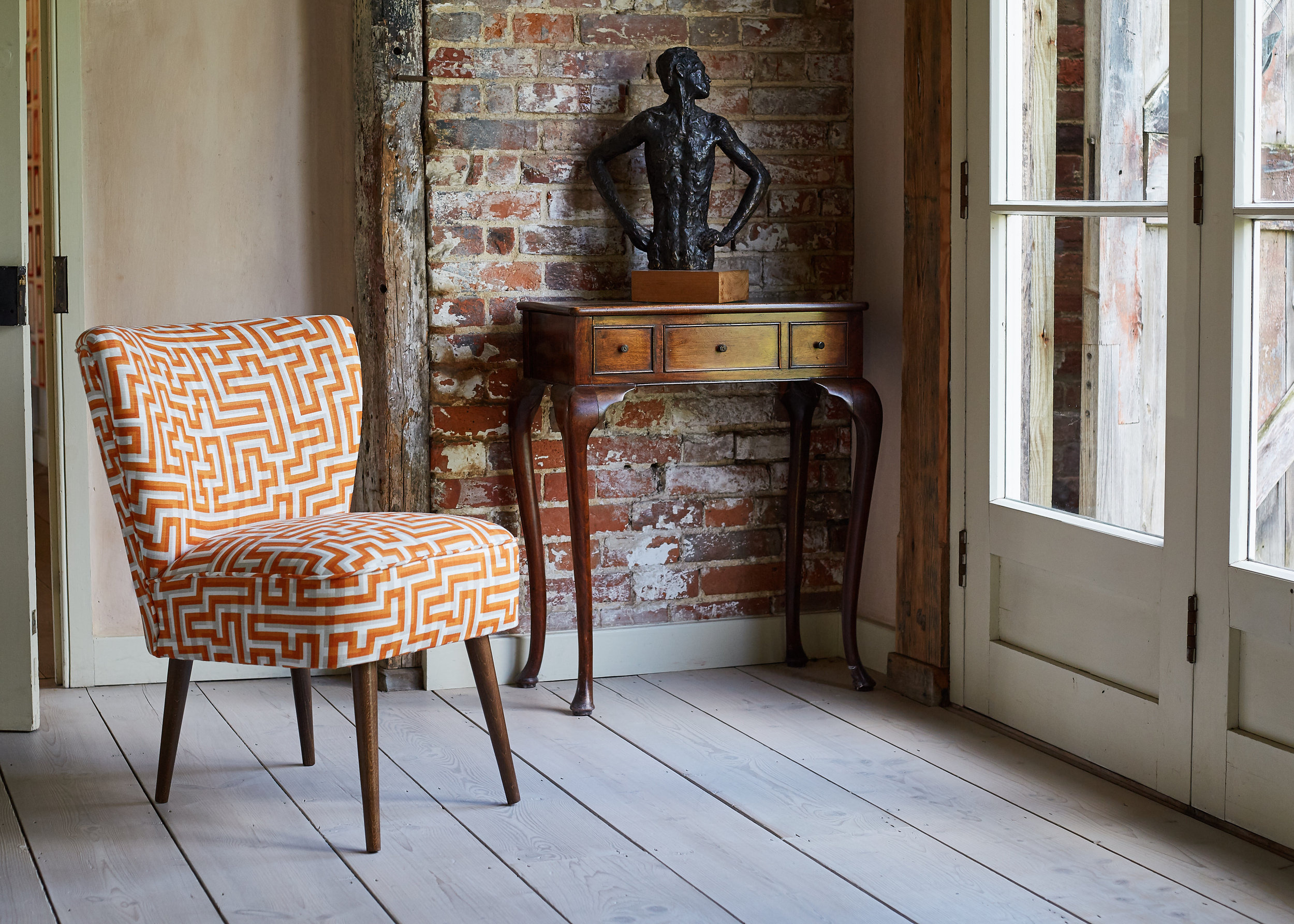 Another lovely chair from Galapagos Designs , looking right at home in this corner alongside the antique side table and bronze. 