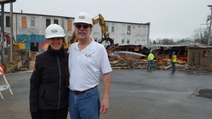 Jeff and Martha Huebner beam with pride as they finally see the first stage of their plan come to fruition. The demolition of the cinder block building in front of what was once the Rouse & Hazard bike factory makes way for the Trefzger’s Bakery move to Peoria Heights.