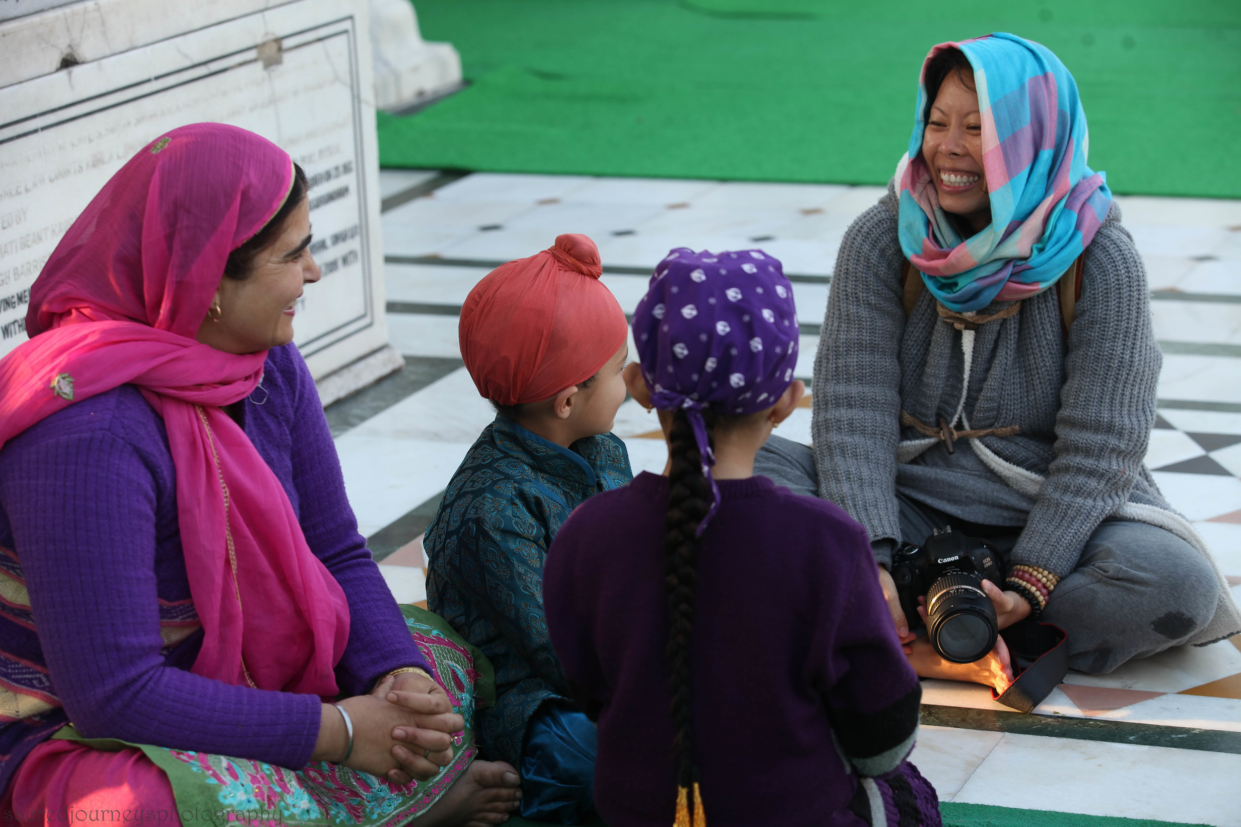 Rita from Hong Kong, having a great time with a family on the Parkarma of the Golden Temple in Amritsar India ~ Sacred Journeys INDIA encourages positive cultural exchanges