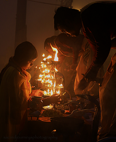  Lighting the butter lamps for the early morning Aarti ceremony at Assi Ghat in Varanasi