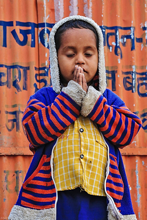 children boy in prayer pose striped sweater Varanasi.jpg