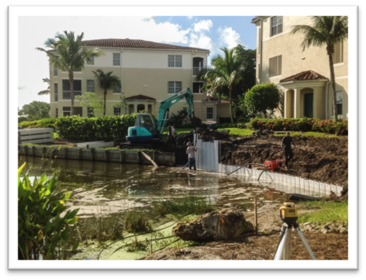 Vibrating hammers into lakebed and removing old wooden wall.