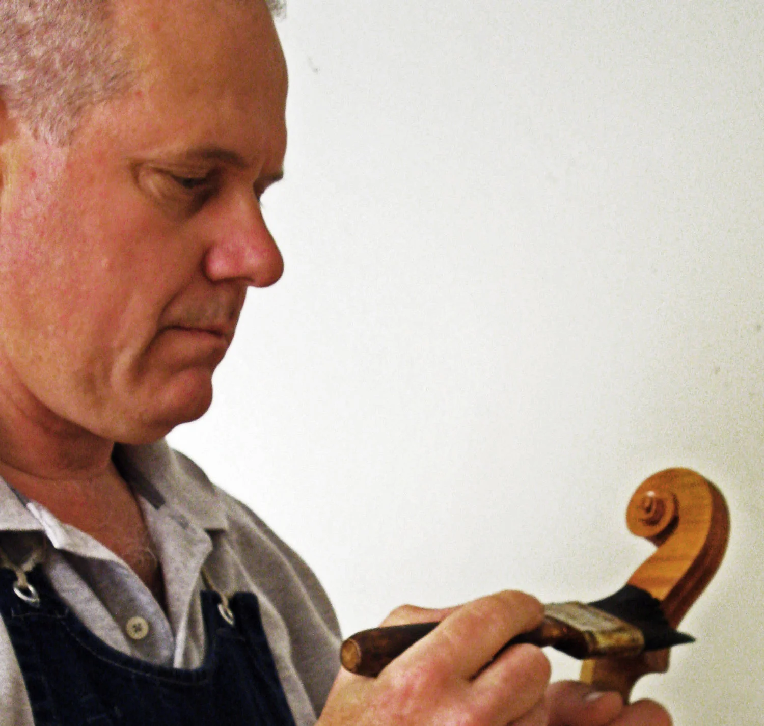 Jim McKean varnishing a violin scroll