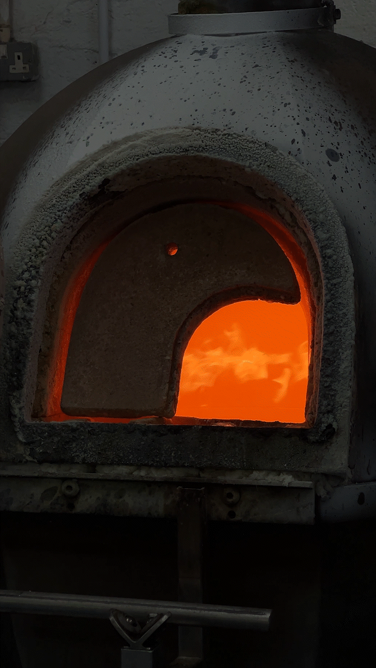 A furnace or kiln with glowing orange interior heating elements.