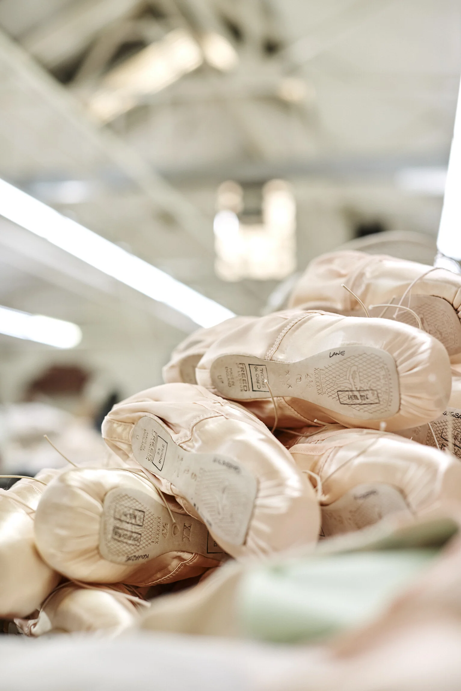 Close-up of ballet pointe shoes stacked in a store or backstage area.