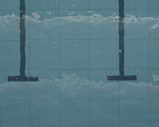 Two pool lane markers submerged in a swimming pool with water ripples.