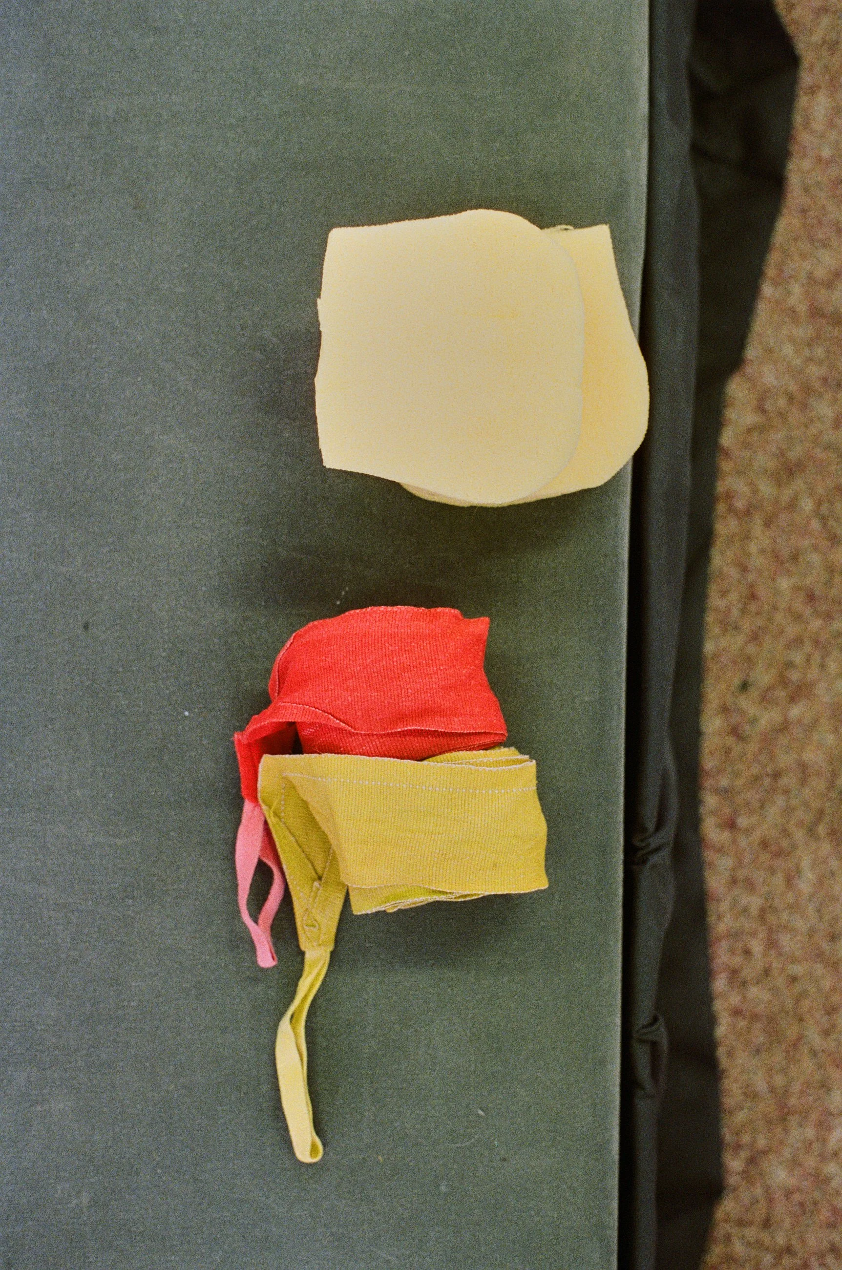 Colored dance ribbons and a piece of dance tape on a dark surface.