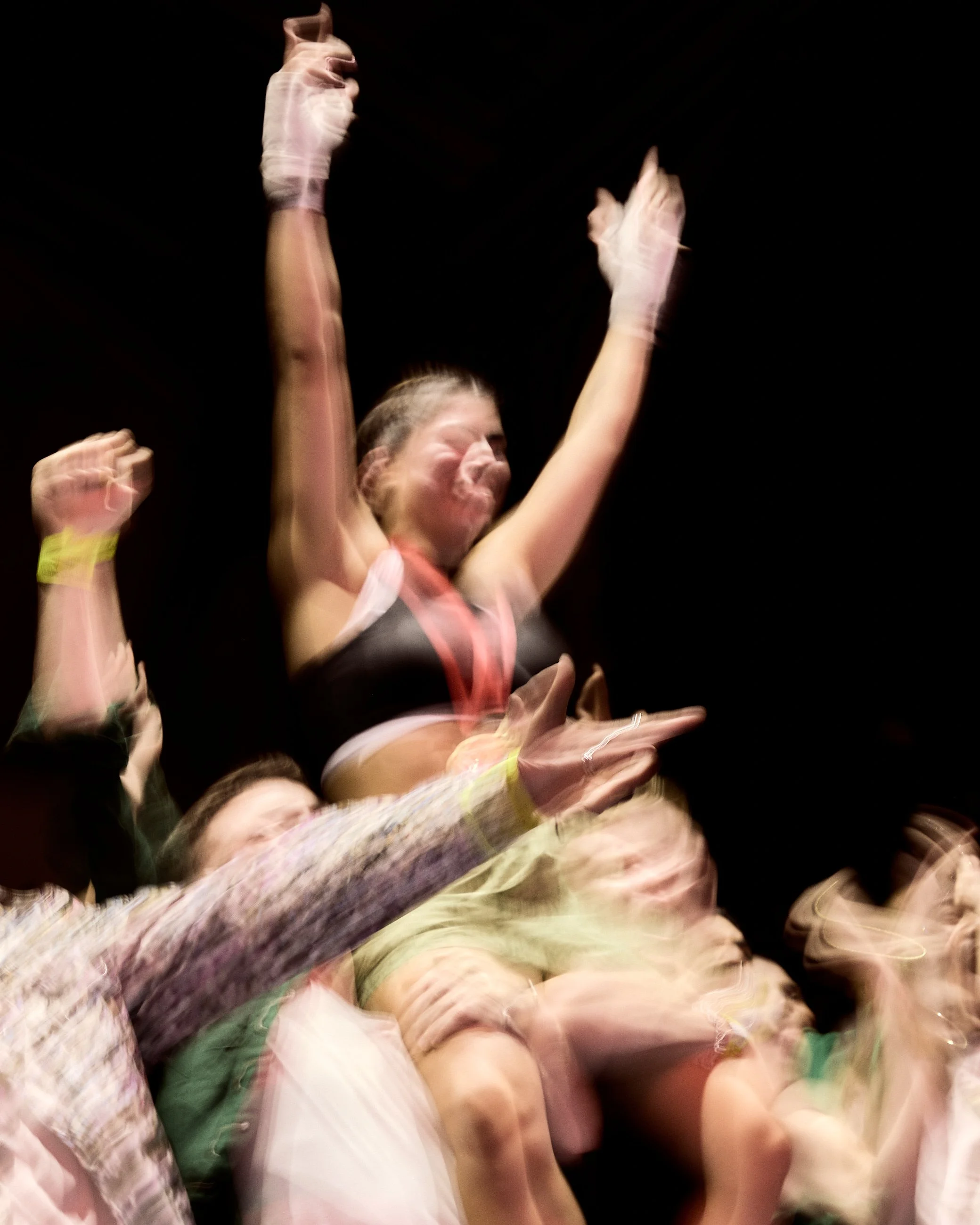 People at a concert or event with their hands in the air, showing motion blur.