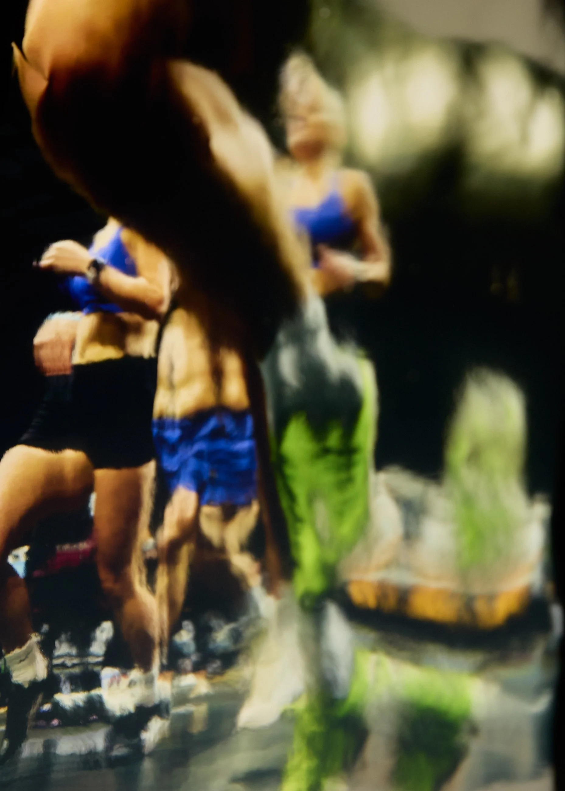 People running outdoors in athletic clothing, captured in motion on a sunny day.