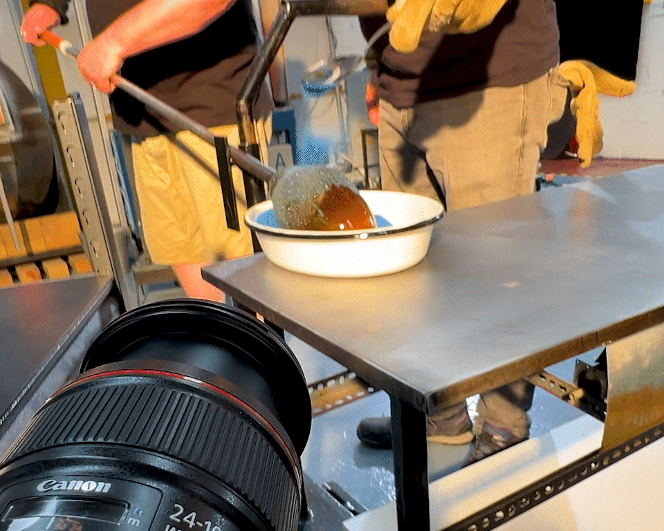 Two people preparing caramel in a kitchen or studio setting, with a professional camera capturing the process.