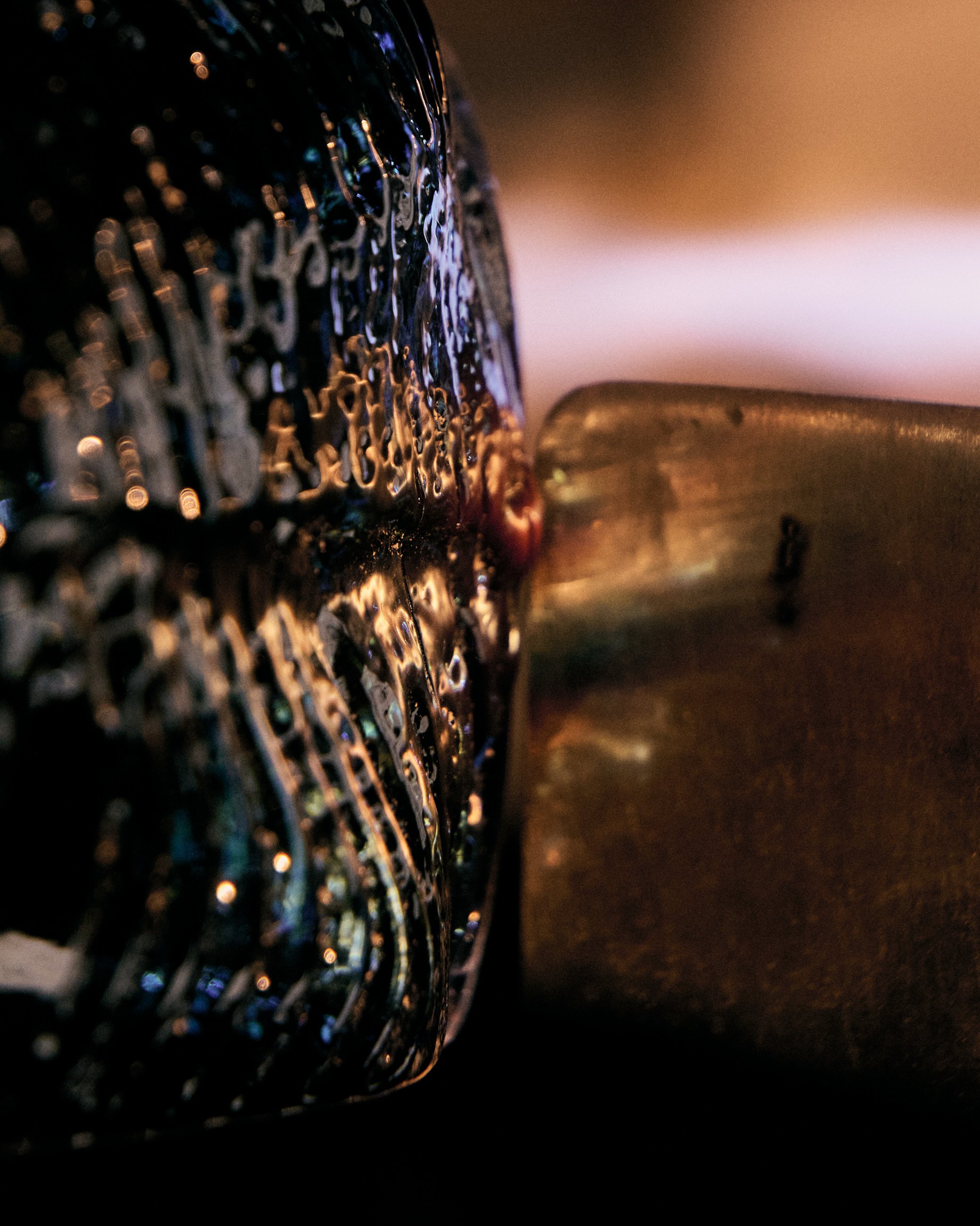 Close-up of a lit candle with melted wax on its surface.