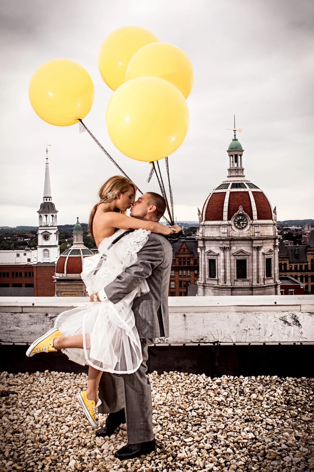 Meagan & Chris - York, PA - Shot from the roof of the Yorketown Hotel. This is another where we just almost ran out of time before shooting. We headed up the stairs, were let out on the roof to this just amazing view of this beautiful historic town. Meagan couldn't do wrong all day, every shot of her was better than the last, to the point where Katie and I finally had to say enough is enough, let's let them get to their reception. We asked her to jump on Chris holding her balloons and this is what we got, easy, beautiful. 