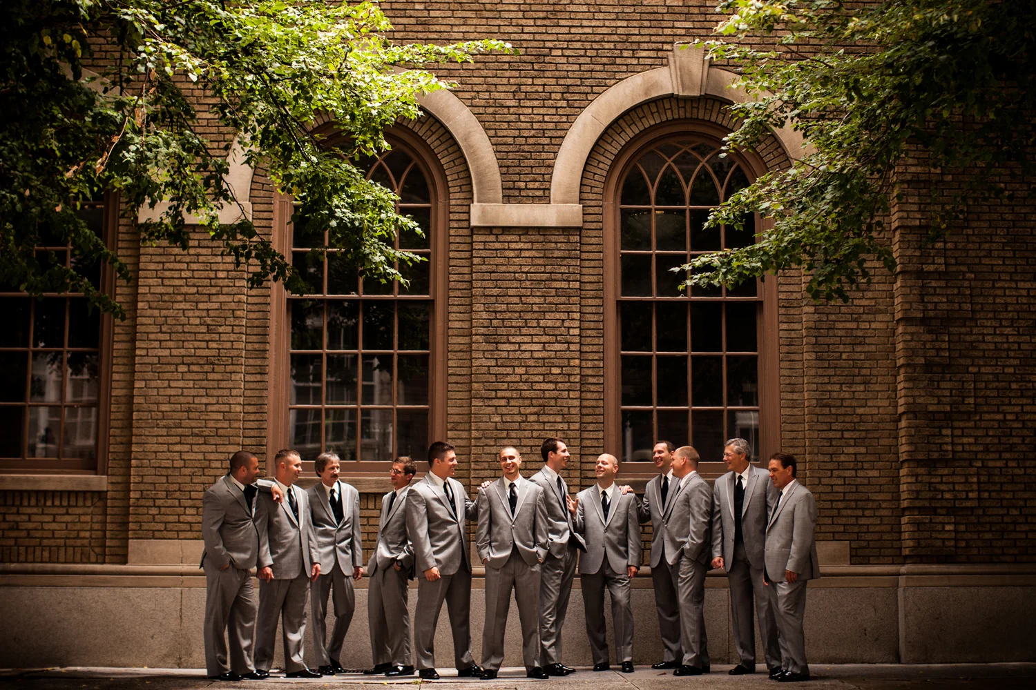 Meagan & Chris - York, PA - Getting this many guys to cooperate for your vision of a creative shot is not always the easiest thing to do. But what I loved about this was how into they all were. All of them. They were excited for it and when I told them to just act natural and joke around, that's all it took and I just snapped away. I was across the street for this one down low to keep the tree branches. I just loved that location and the little bit of light coming through. And of course all their expressions are just awesome. 