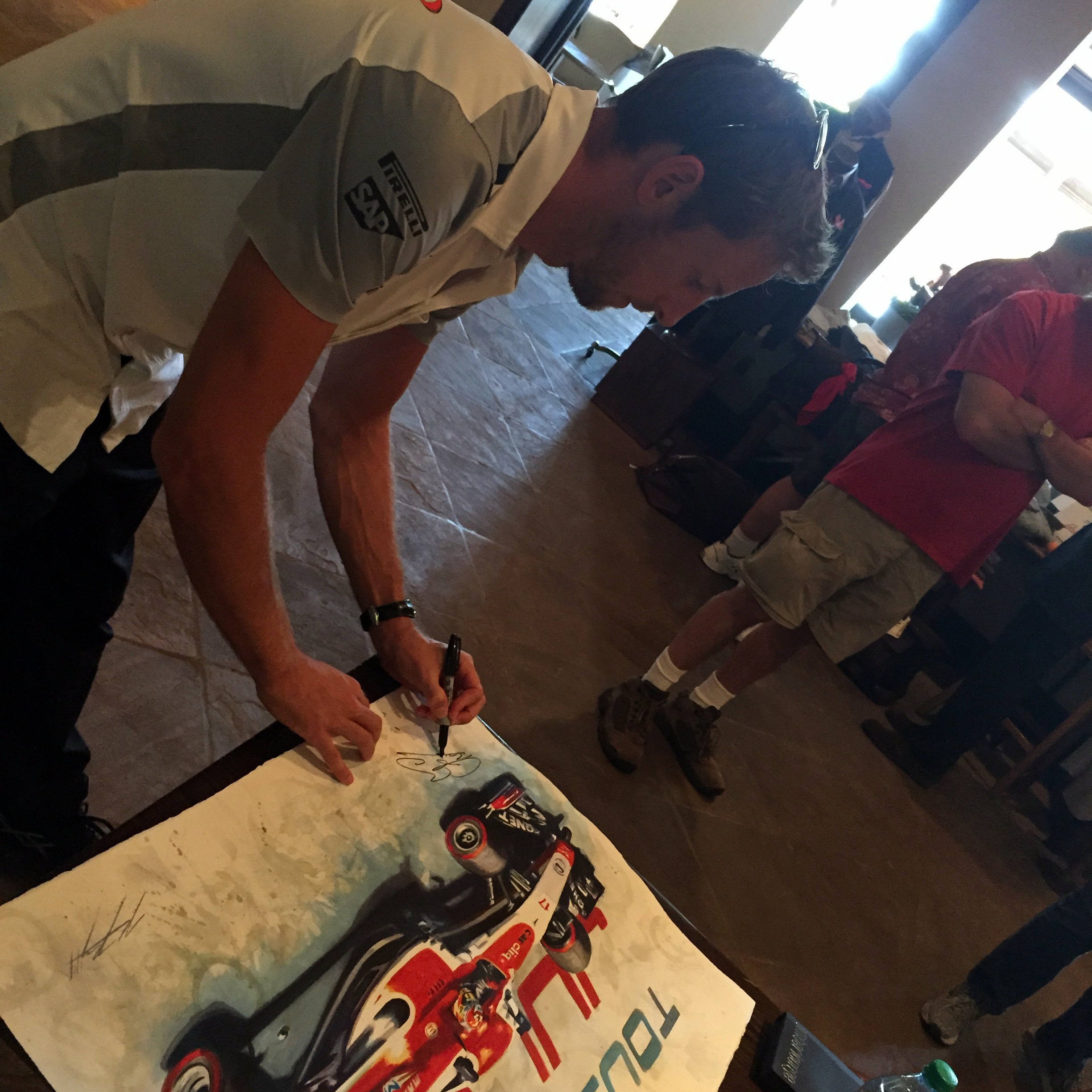  Jenson Button signing a tribute painting 'With You' of Jules Bianchi at the USGP 