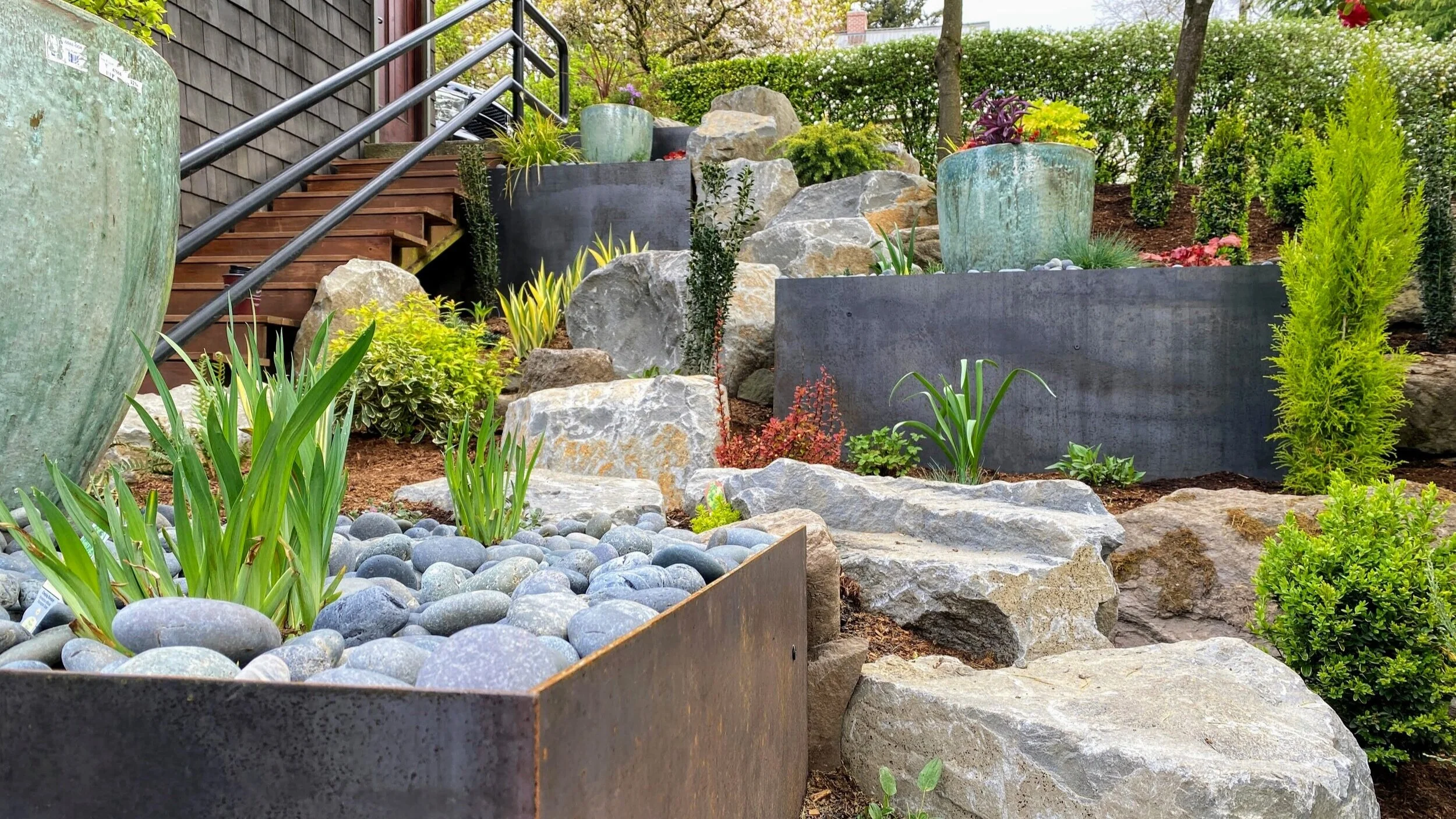 Boulders, corten steel planters, and ceramic pots