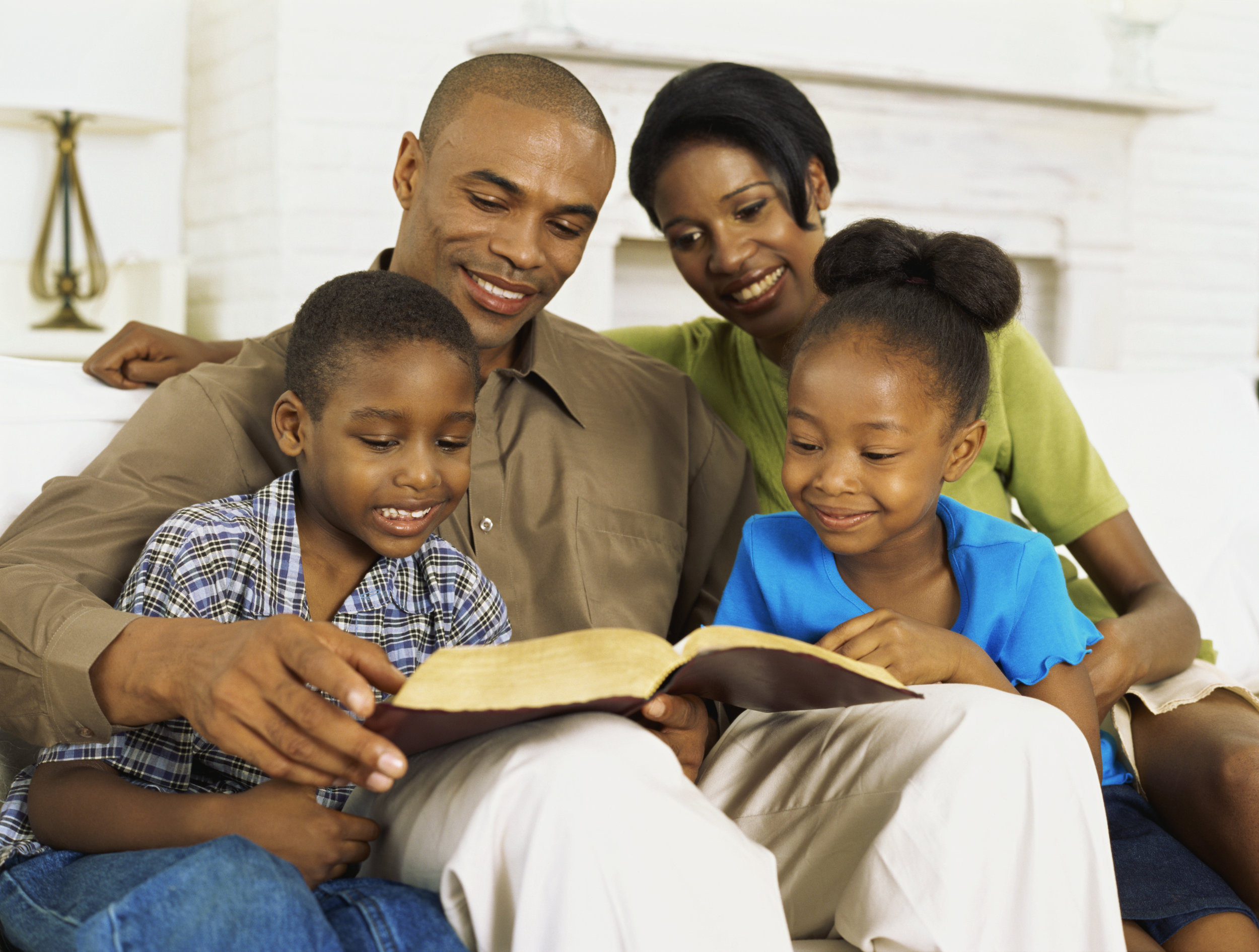E pais. Семья афроамериканцев. Семья темнокожих за столом. Общение с темнокожими. Чтение Библии в семье.