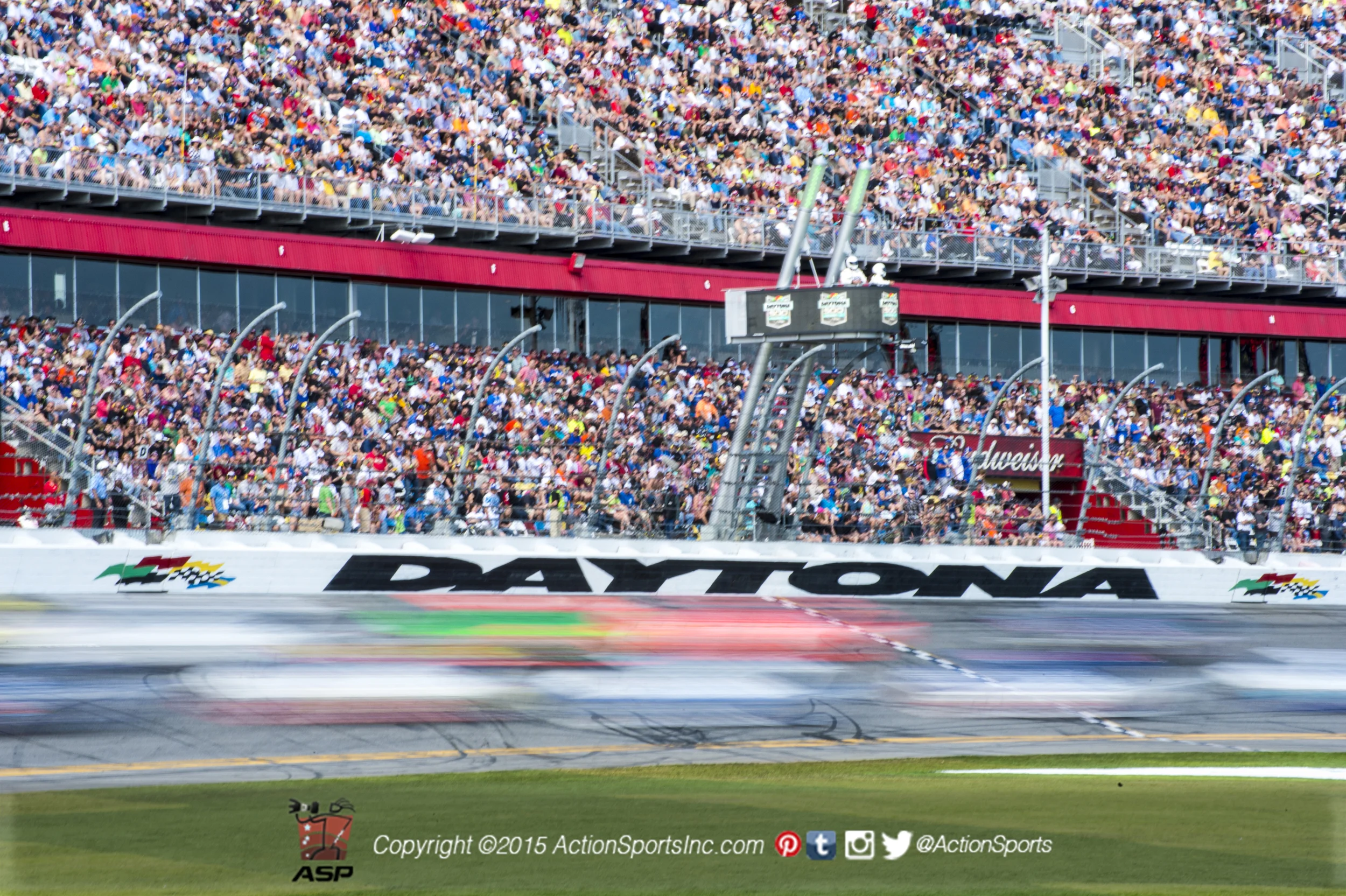 Stock cars race down the front straight of the Daytona International Speedway in a blur during the Daytona 500