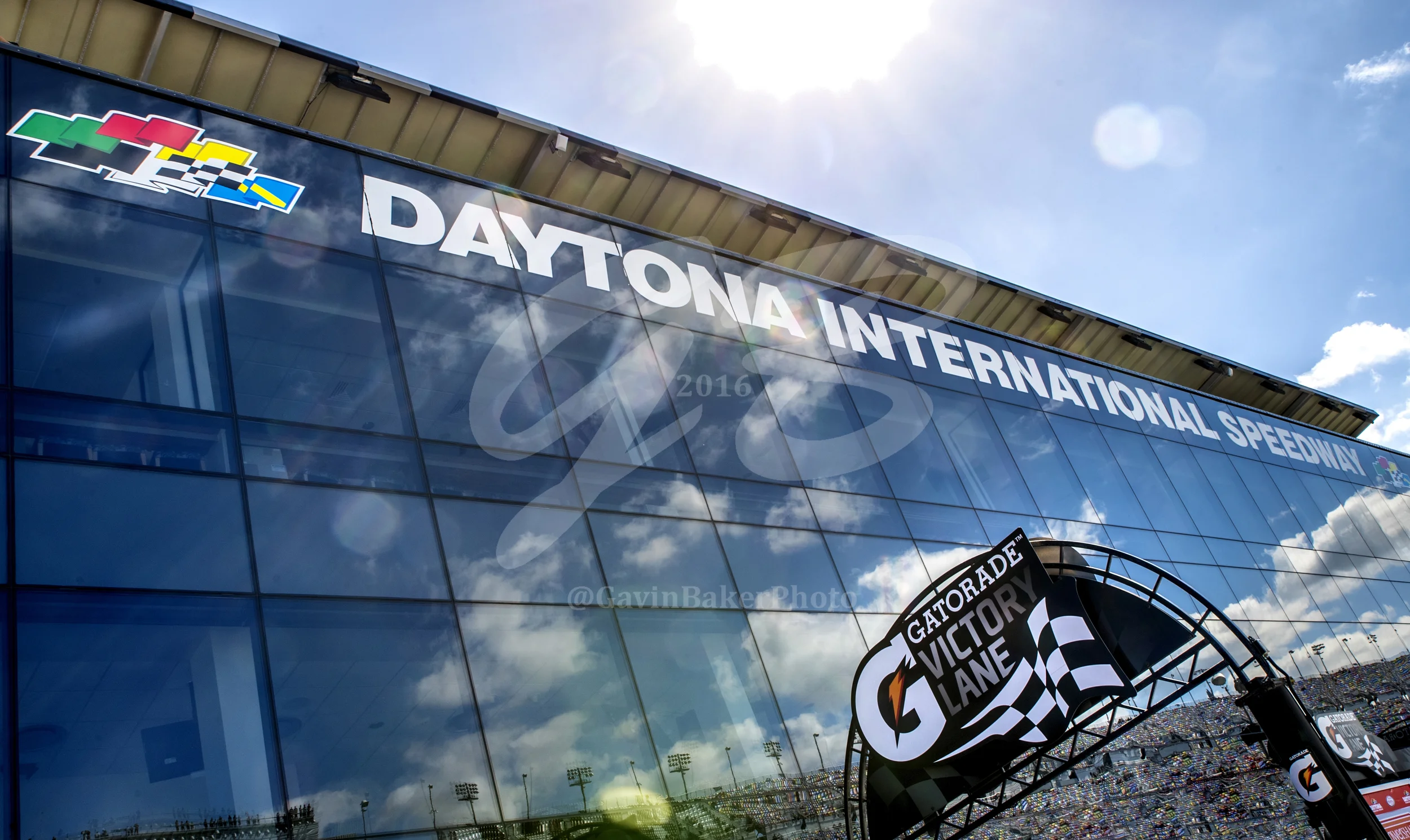 The mirror like windows in Victory Lane reflect the grandstands filled with people