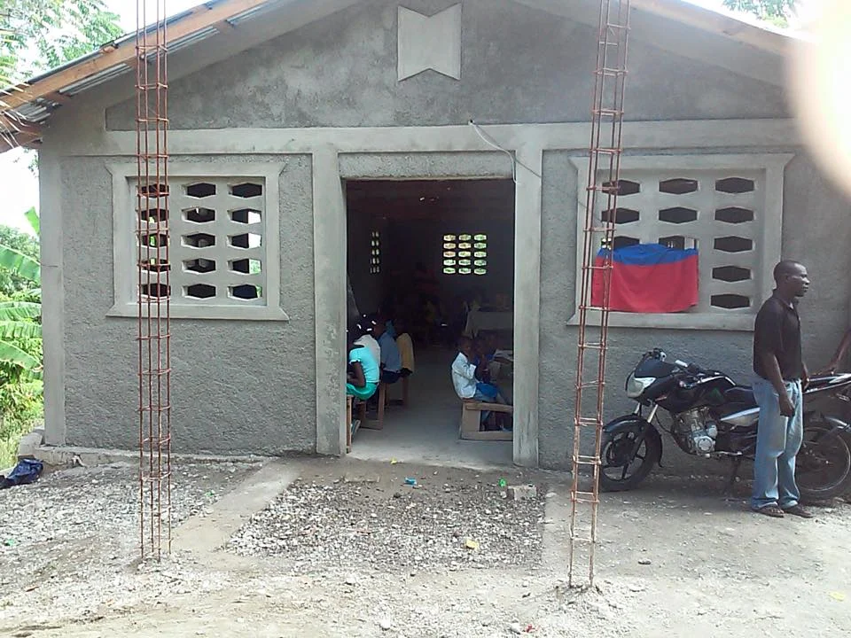 An "After" picture. Besides the rebar sticking of of the ground, not much is the same. You can see the school children just inside the door. You gave them a place to learn. 