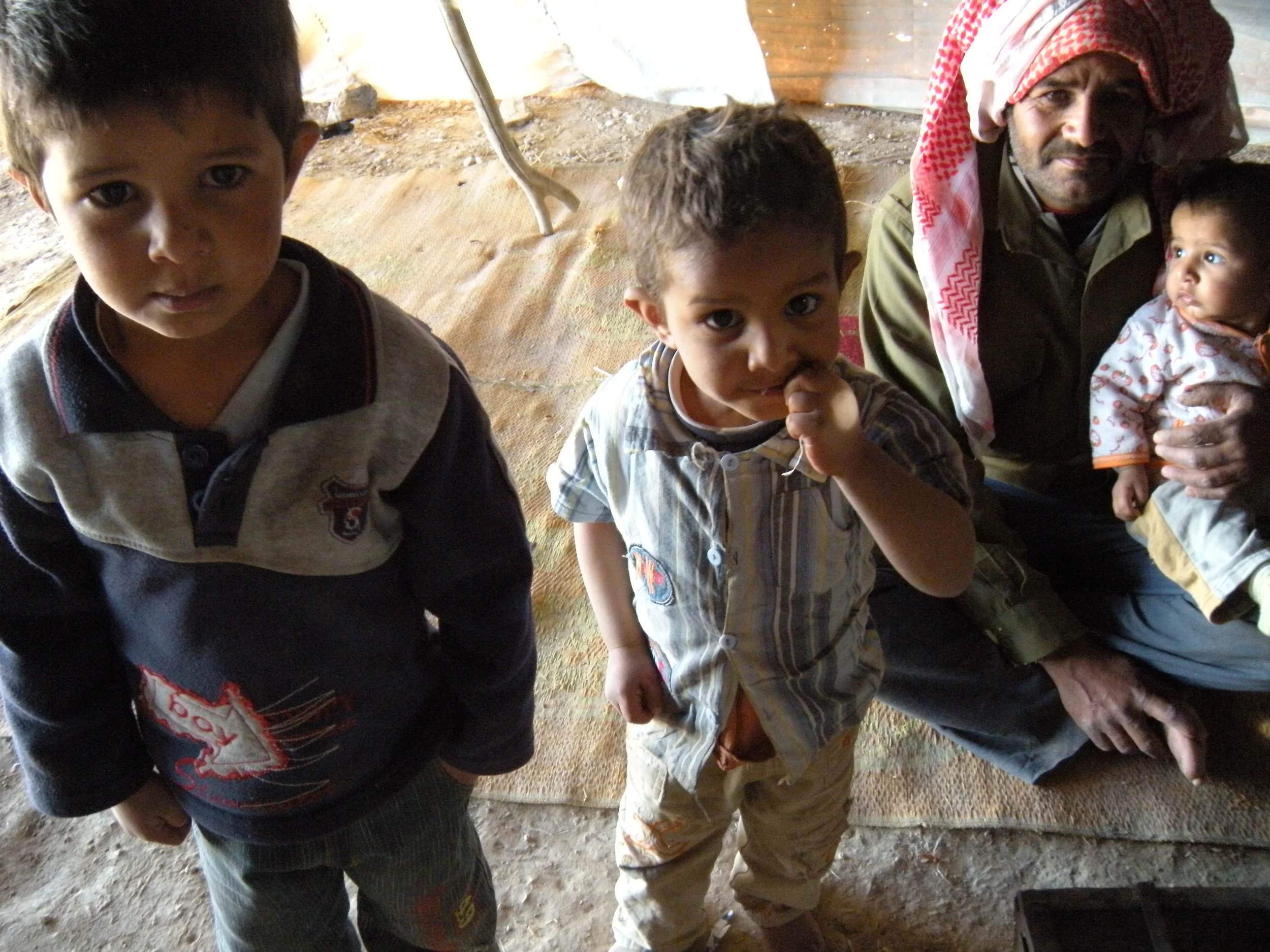 Bedouin boys and father in family tent, Jordan