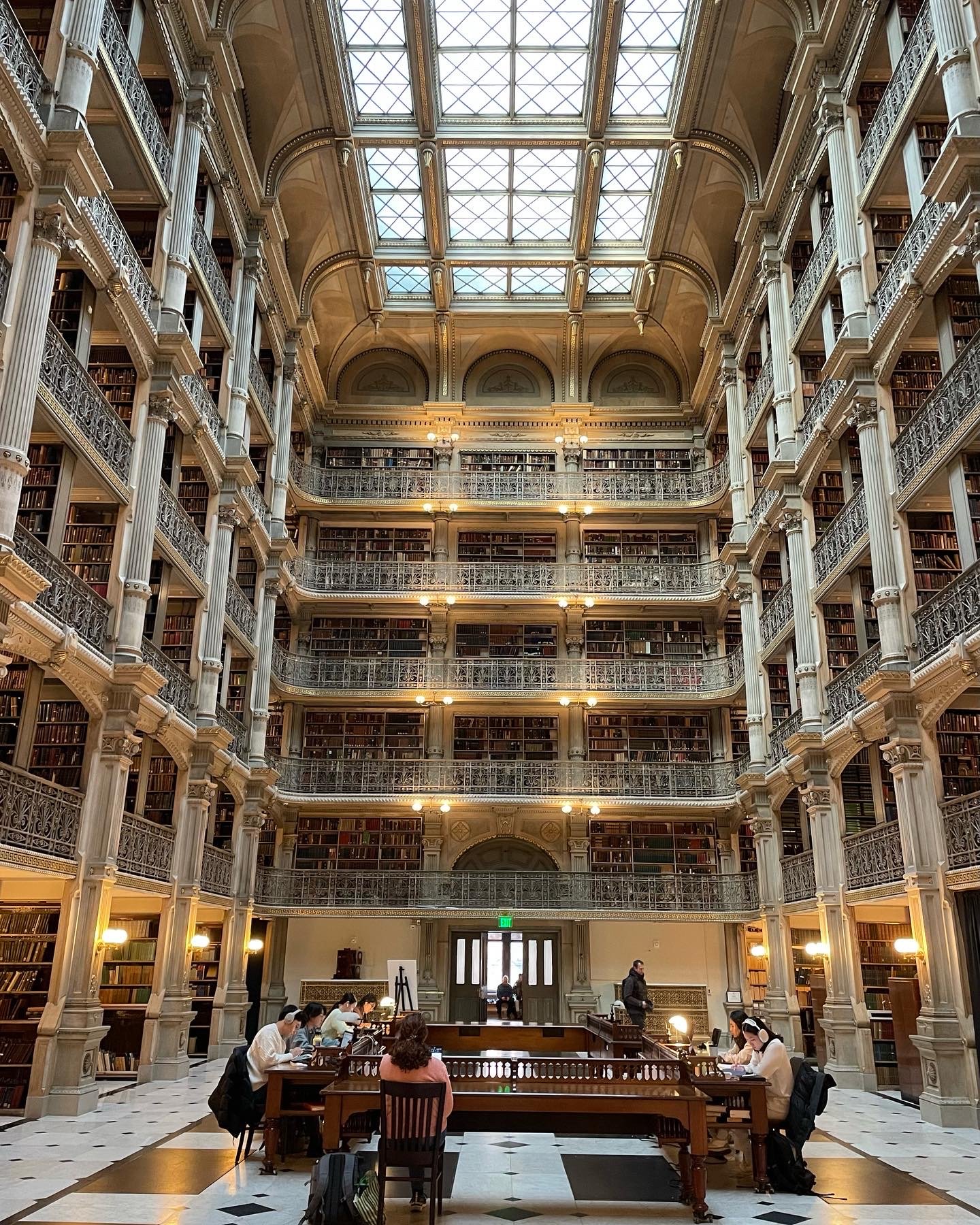 People sit around a table in the George Peabody Library/