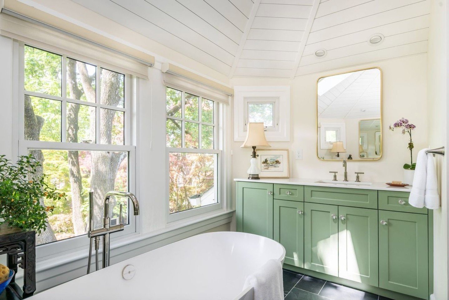 🕰️✨ This stunning bathroom remodel, with its green cabinets and a soaking tub set against windows, remains a masterpiece from our past projects. 🛁💚 
.
.
.
Architect: @cbharchitects
--
#ThrowbackThursday #VintageCharm #BathroomInspiration 
#General