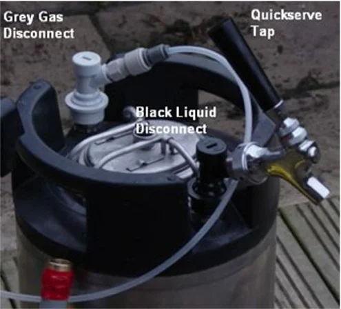 Top of Corny Keg showing grey Co2 disconnect and black liquid-out disconnect and a 'party' tap.