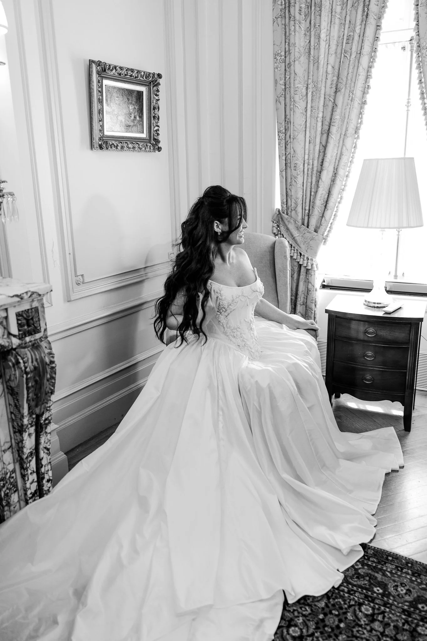 Smiling bride sitting near a window at the Perry Belmont House, ready for the celebration