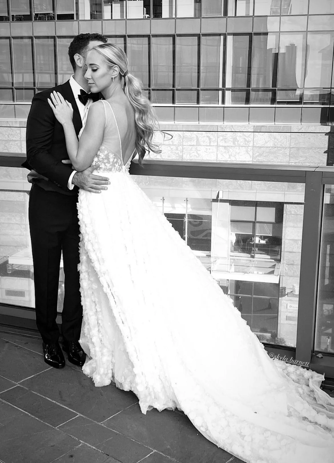 Couple hugging on a balcony and sharing an intimate moment.