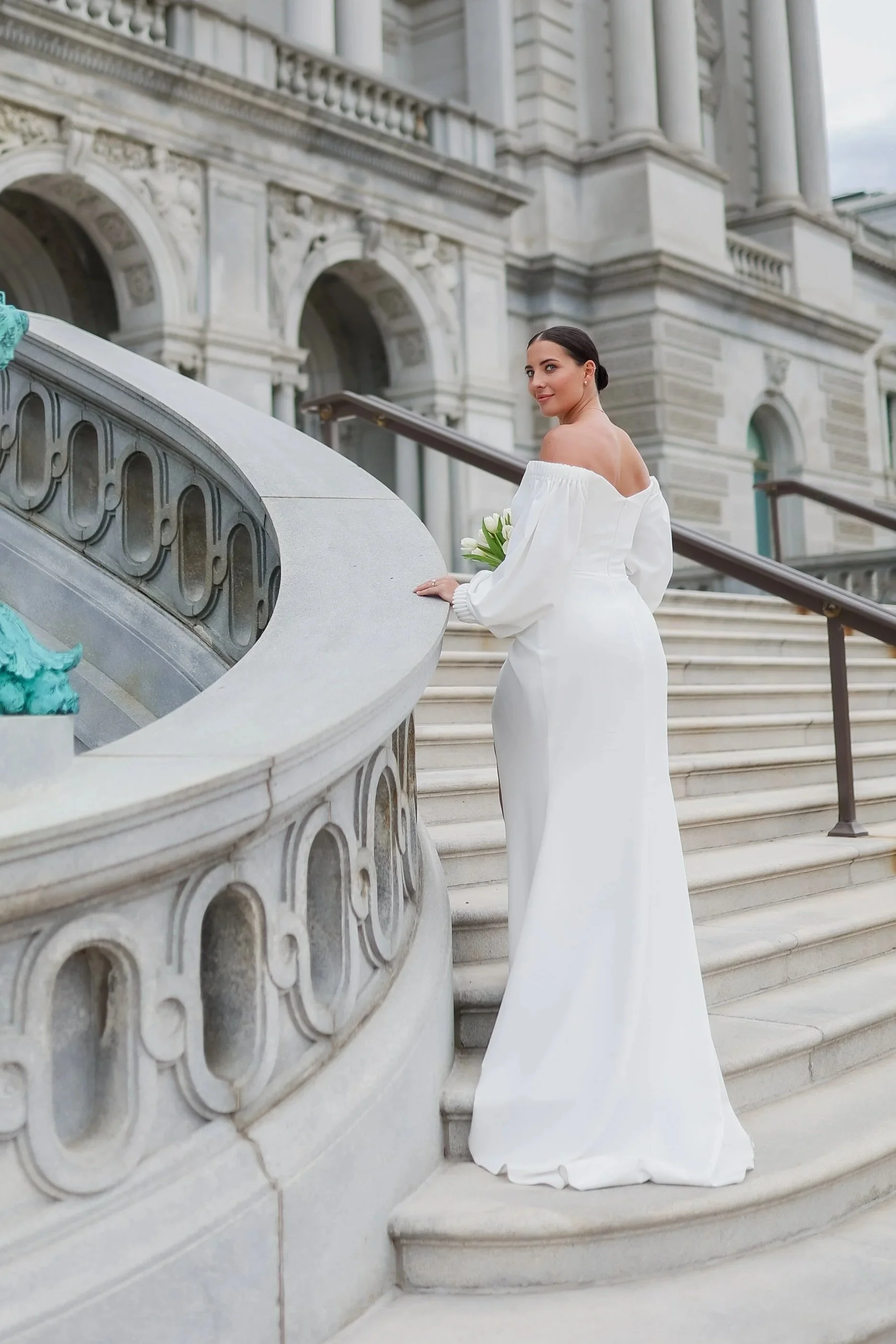 Bride  with sleek bun hairstyle , on the stairs of library of congress