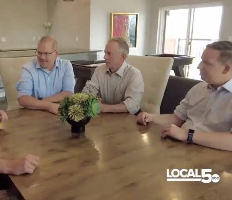 4 White Guys Sitting Around a Table 