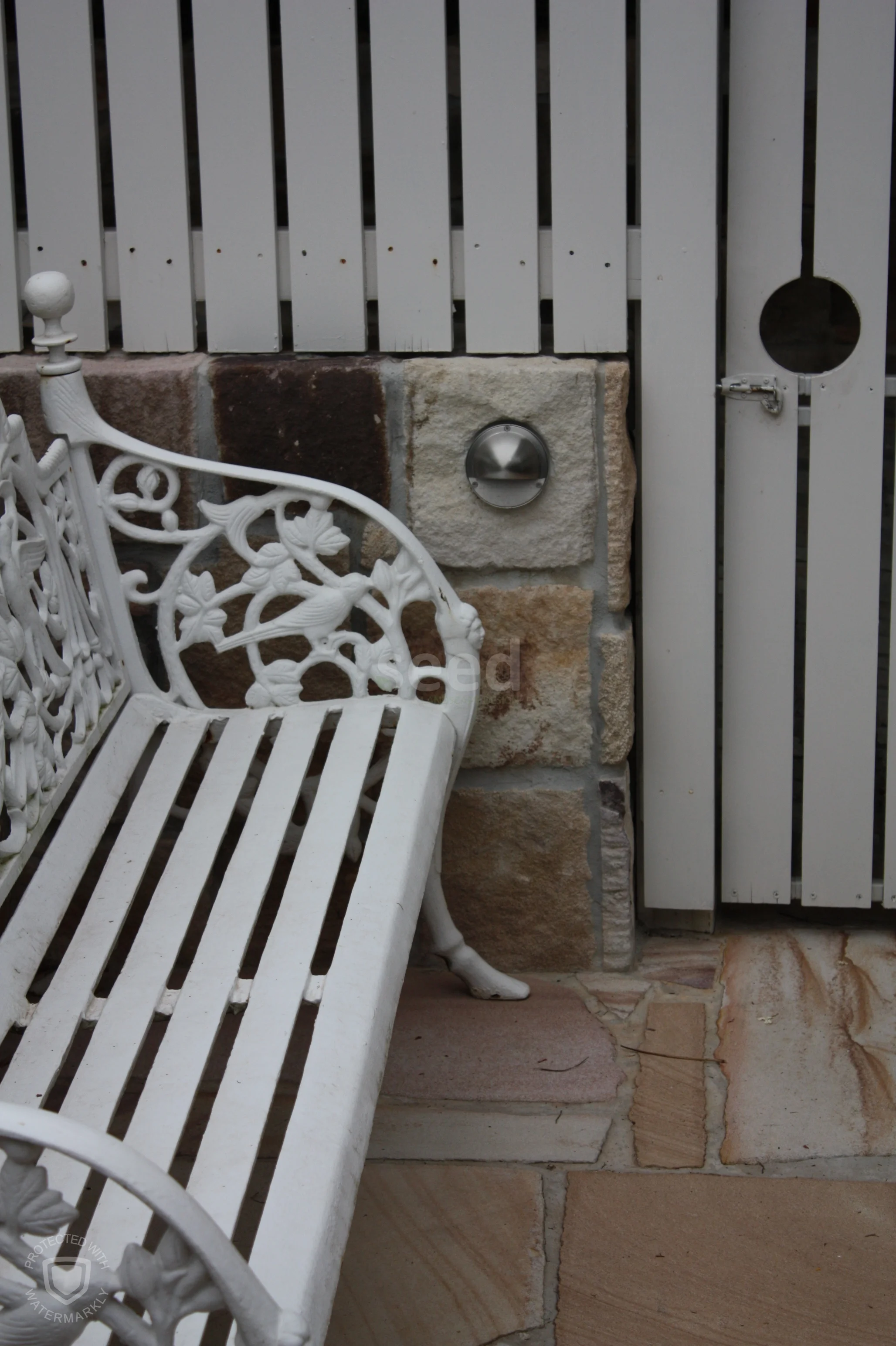 Where the formal courtyard meets the carport. Extending the white picket fence into a screen and gate visually sets the zones apart.