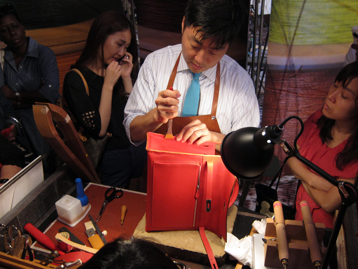  Pinching the side panel along the edge to secure the adhesion to the body of the bag. 