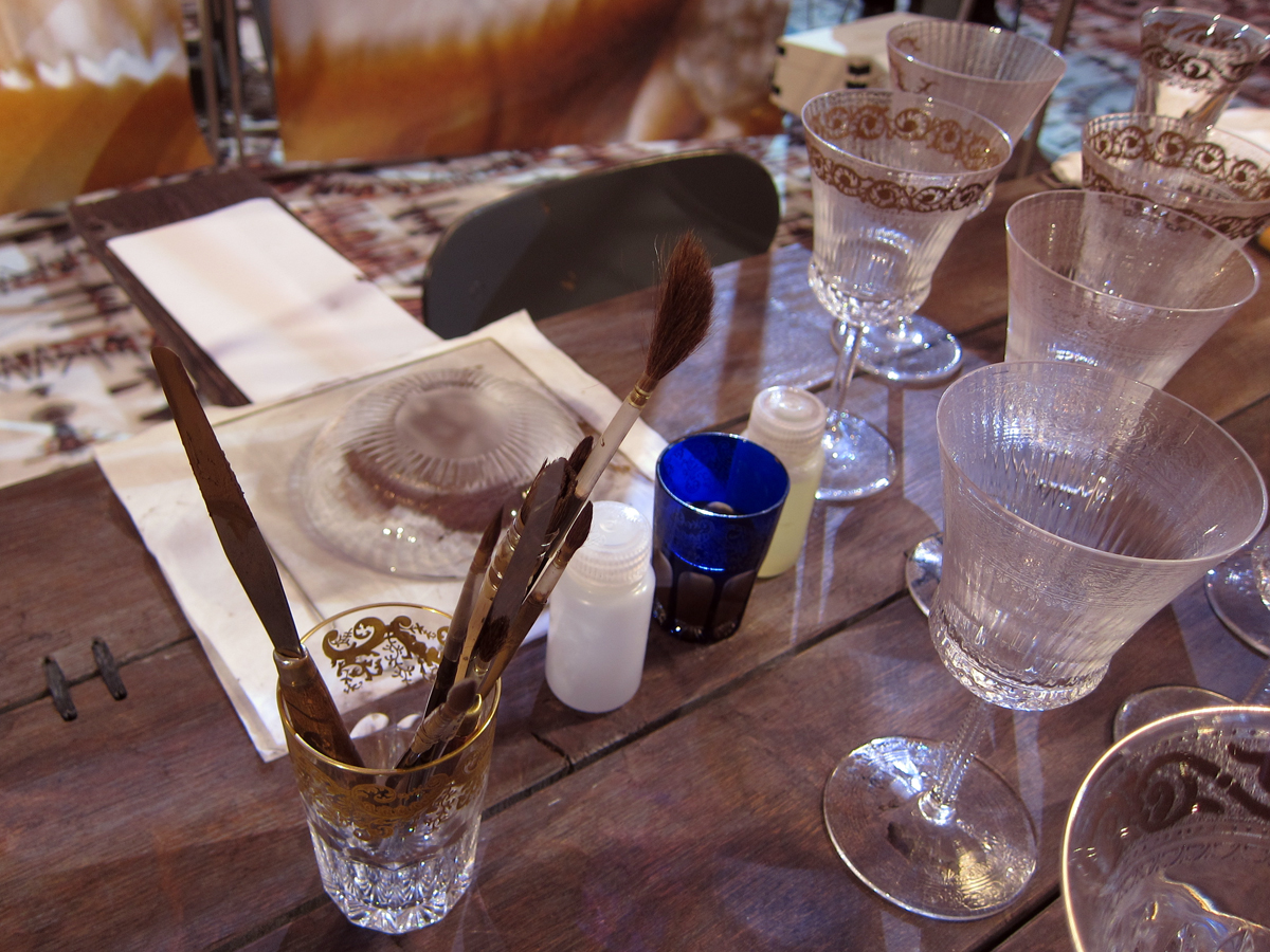 The master gilder's tools set next to stemmed glasses being prepared for their gold.