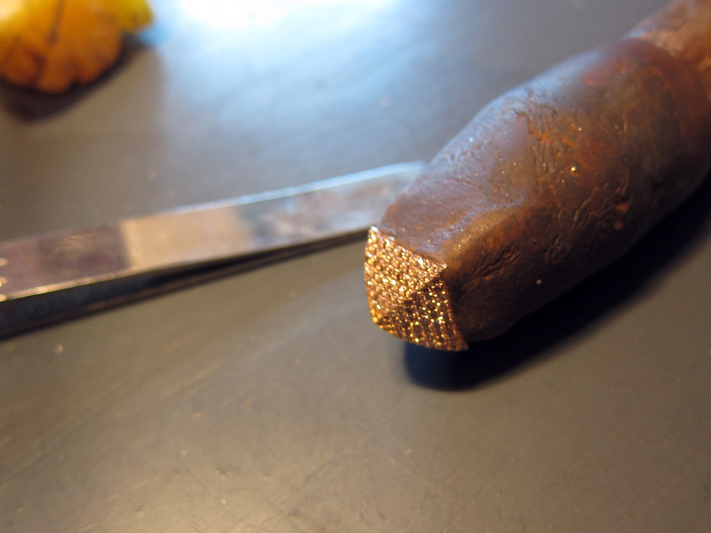  A pave diamond gold stud attached to a waxed work stick. 