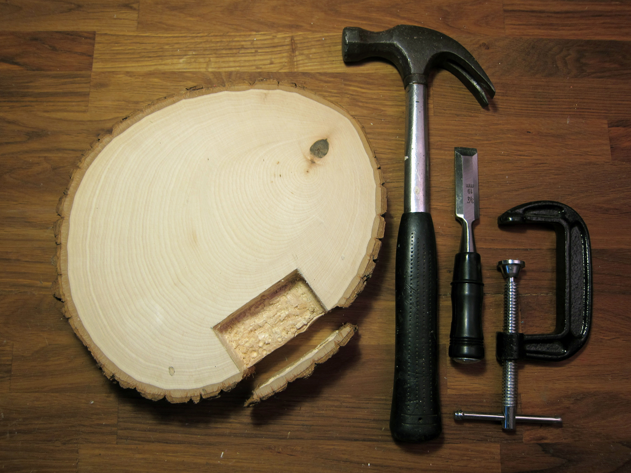  Clamp basswood round to work surface. With a wood chisel and hammer, carefully chisel off the bark edge of basswood next to the tracing marks. Put the bark piece aside. 