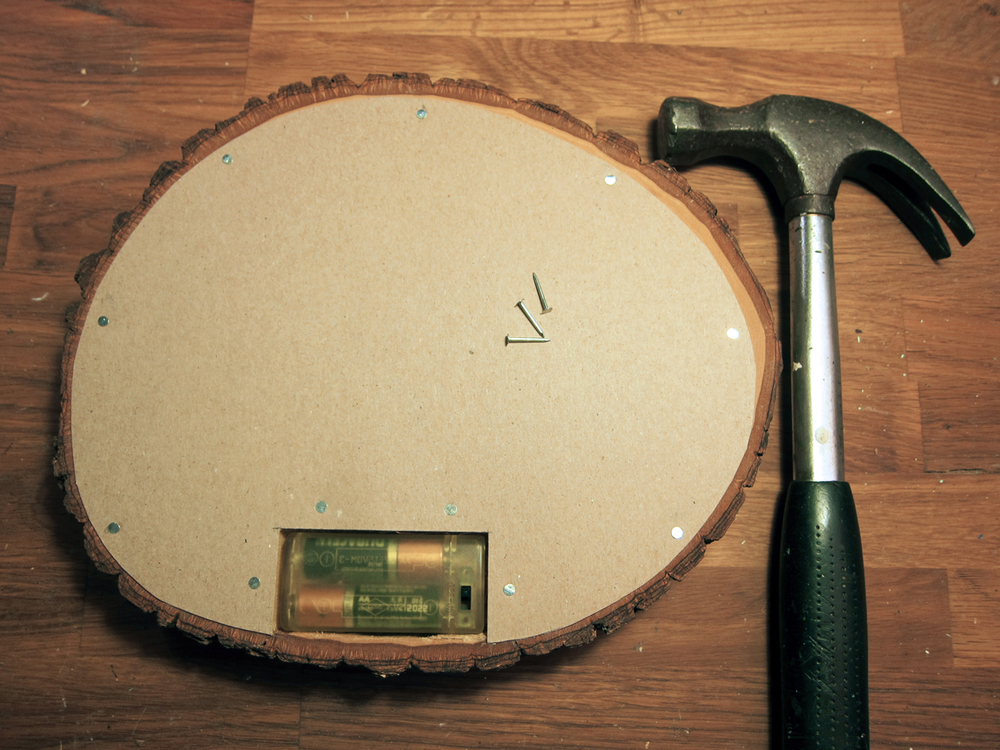  Cut a piece of chipboard to fit the back of basswood round. Cut out a hole where battery pack is.  With wire brad nails and a hammer, secure the clip board to the basswood.   
