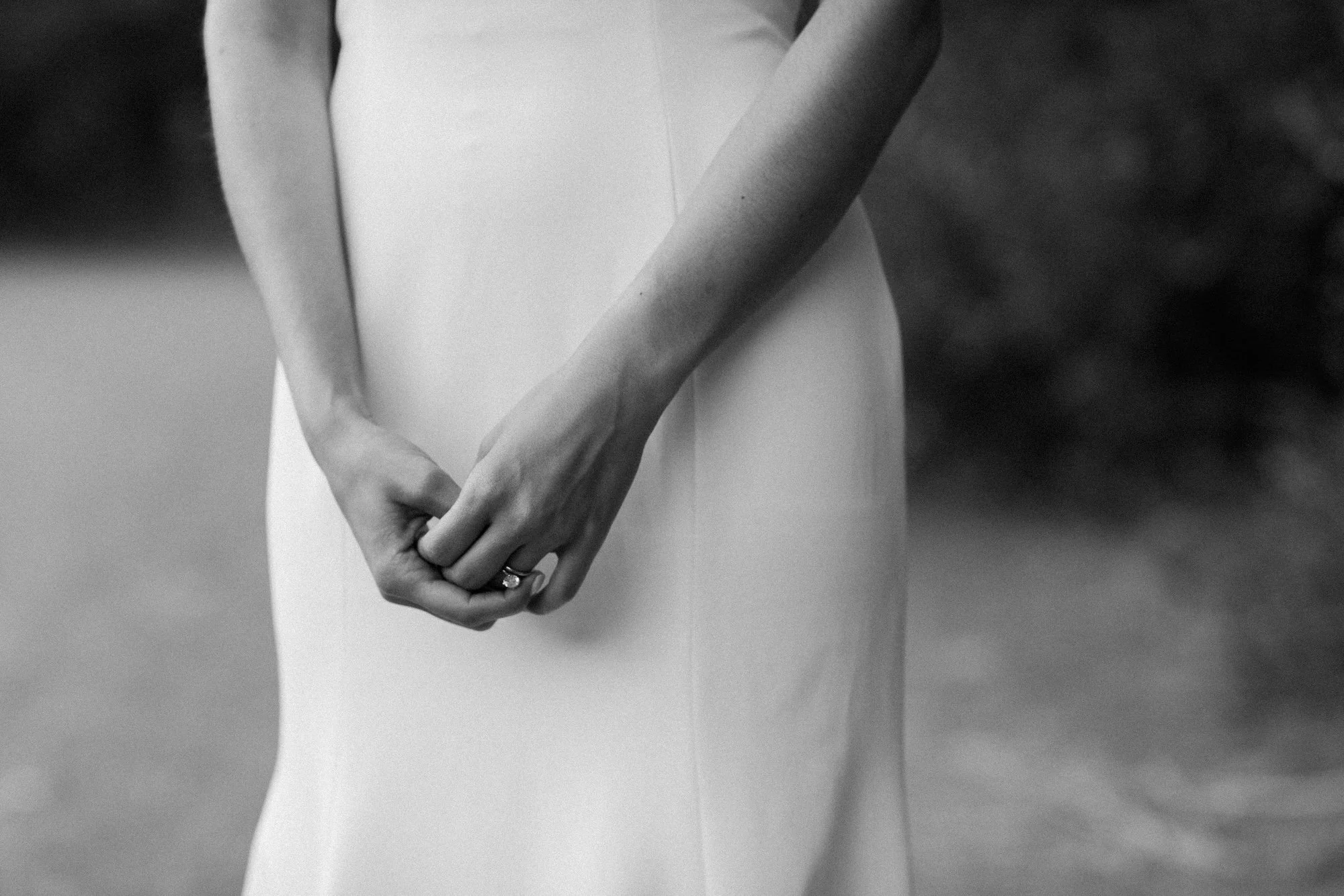 A closeup of a bride playing with her engagement ring.