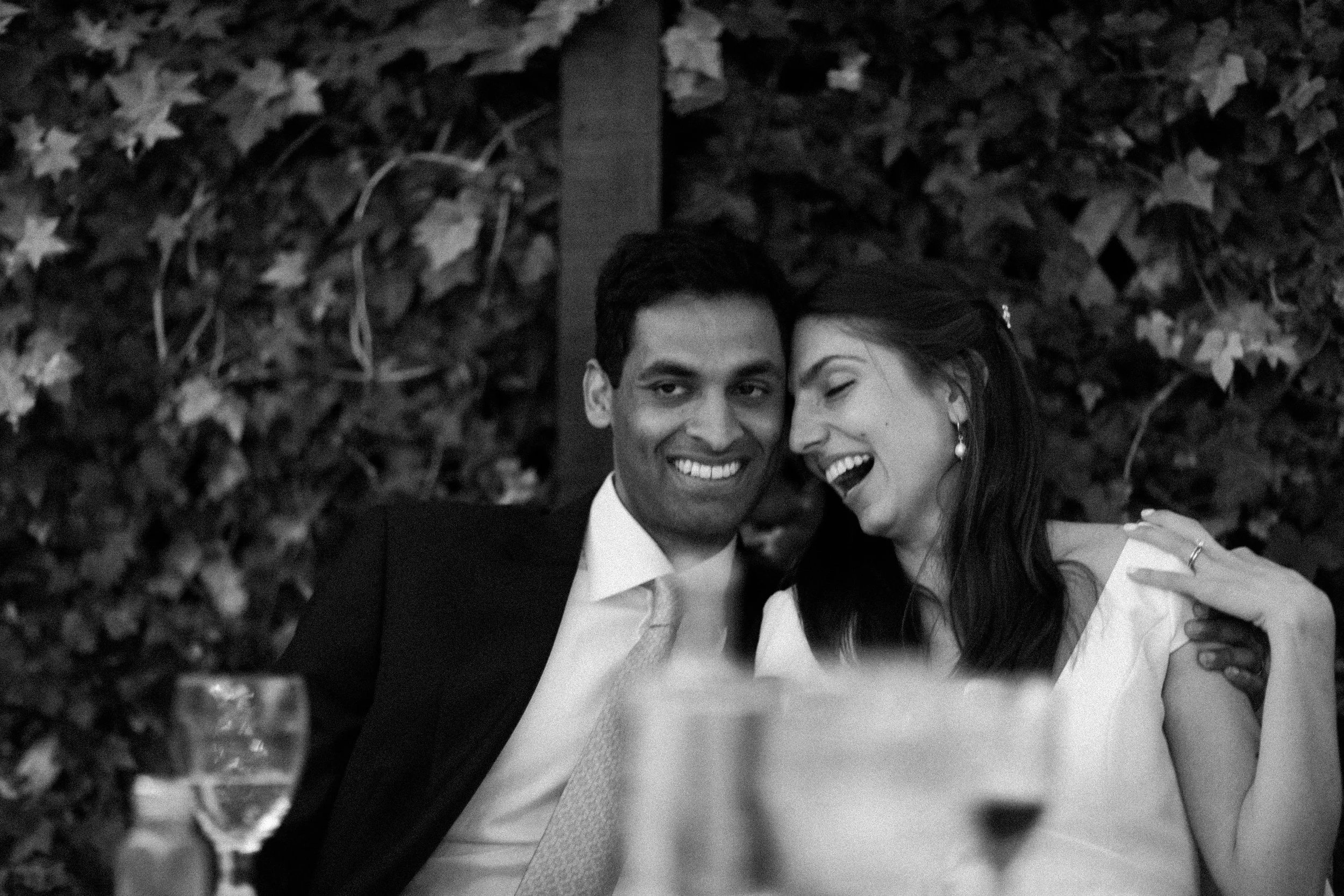 Bride and groom laughing during their dinner reception.