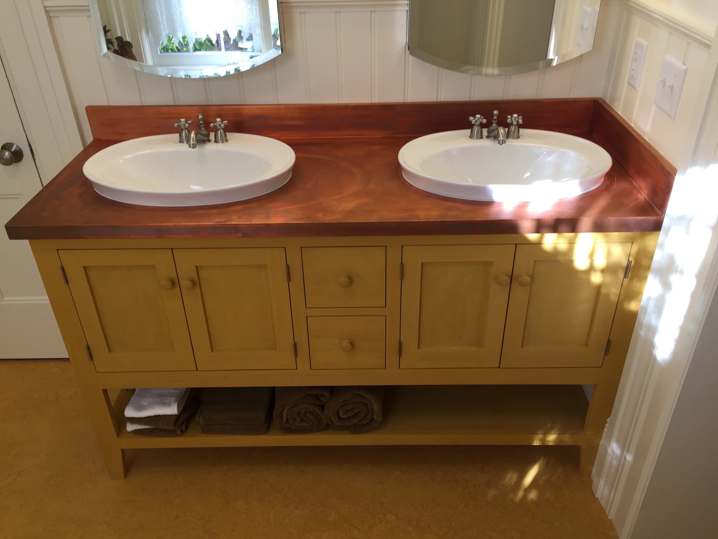  JFB designed and built this custom vanity with copper countertop. The homeowners chose a bold mustard milk paint to give an original touch to the room. 